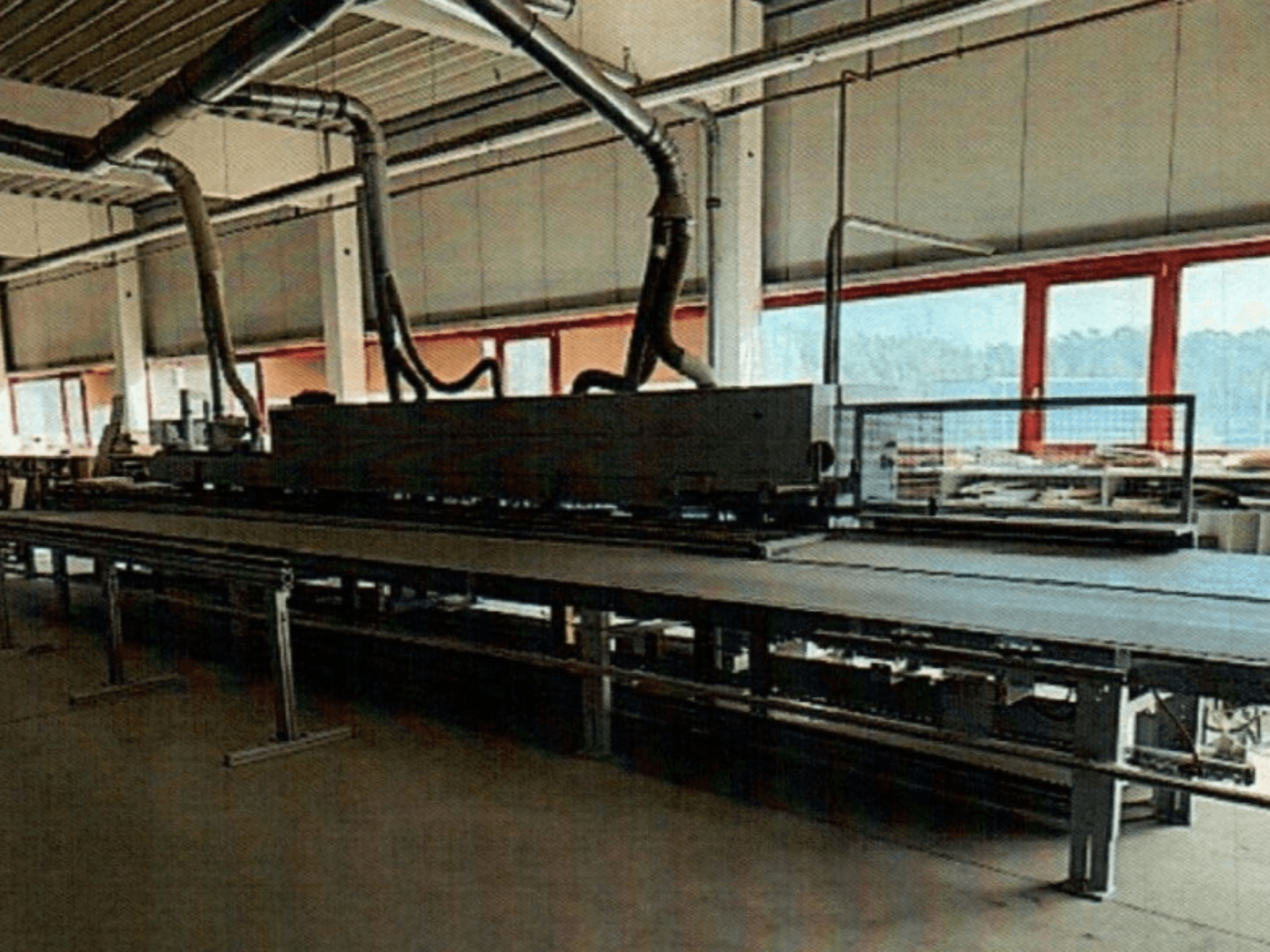 HOMAG KAL 370 kantenbewerker in een werkplaats, zijaanzicht, met de lange, vlakke werktafel met ventilatiekanalen erboven.