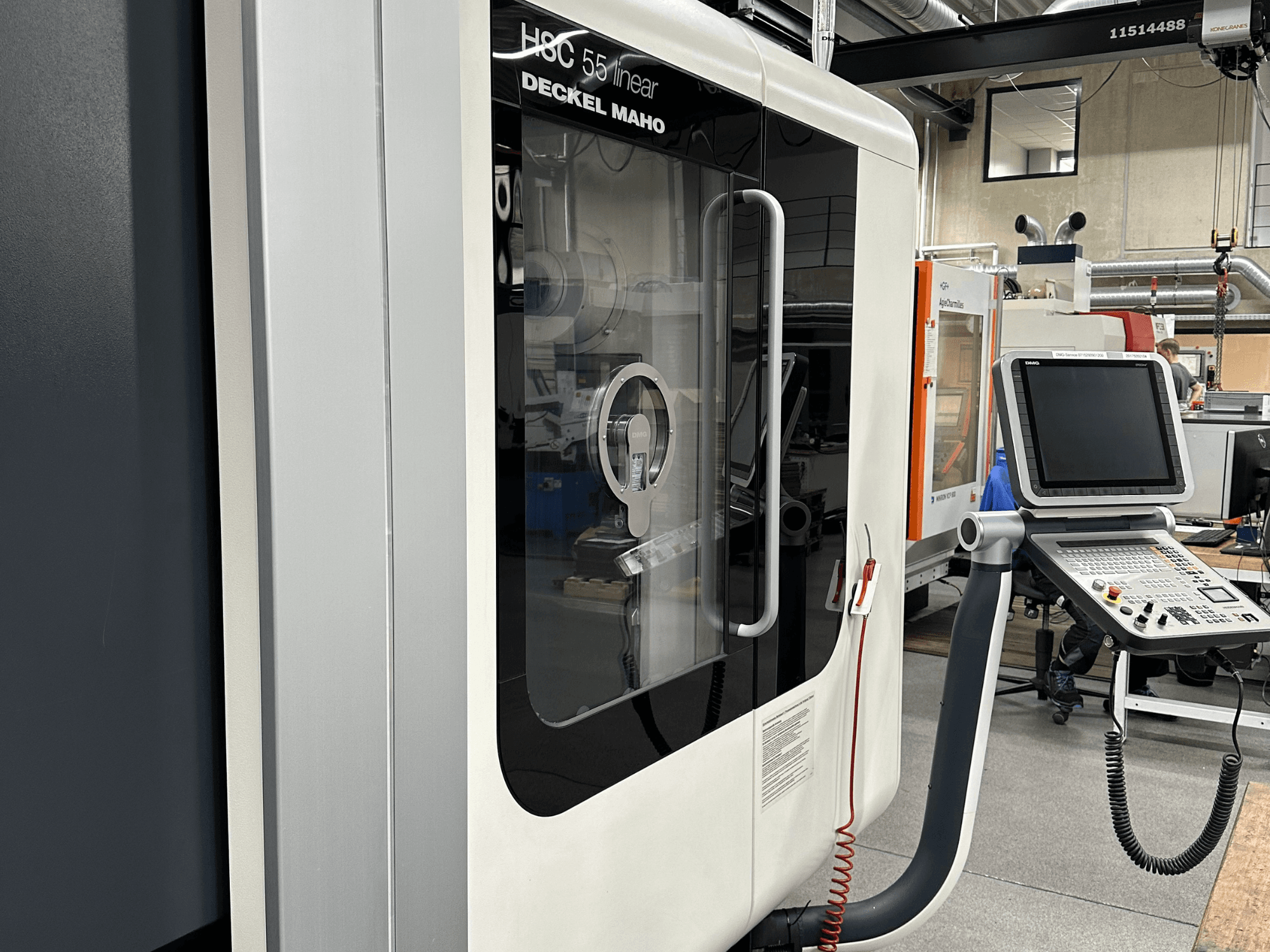 Deckel Maho HSC 55 lineaire freesmachine gezien vanaf de voorkant, met een bedieningspaneel en transparant paneel om het interieur te bekijken.