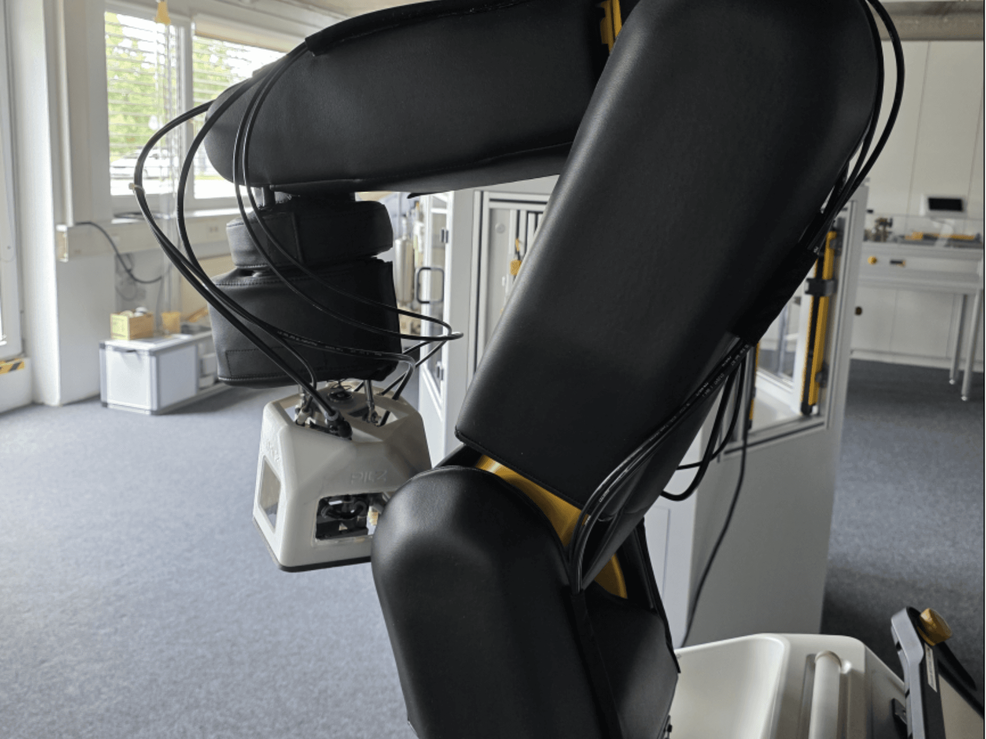Zijaanzicht van de FANUC LR Mate 200iD/7L-samenwerkende robot, met de arm en sensoren, en zichtbare kabels in een werkplaatsomgeving.