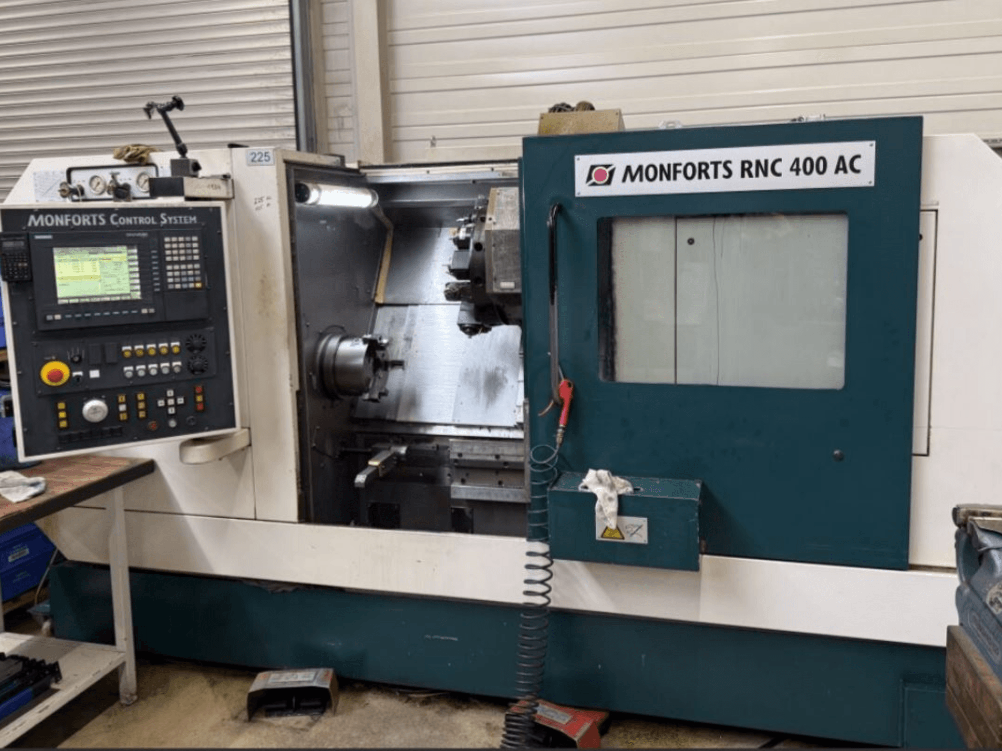 Monforts RNC 400 AC horizontale draaimachine, vooraanzicht, met het bedieningspaneel en het bewerkingsgebied met zichtbare gereedschappen.