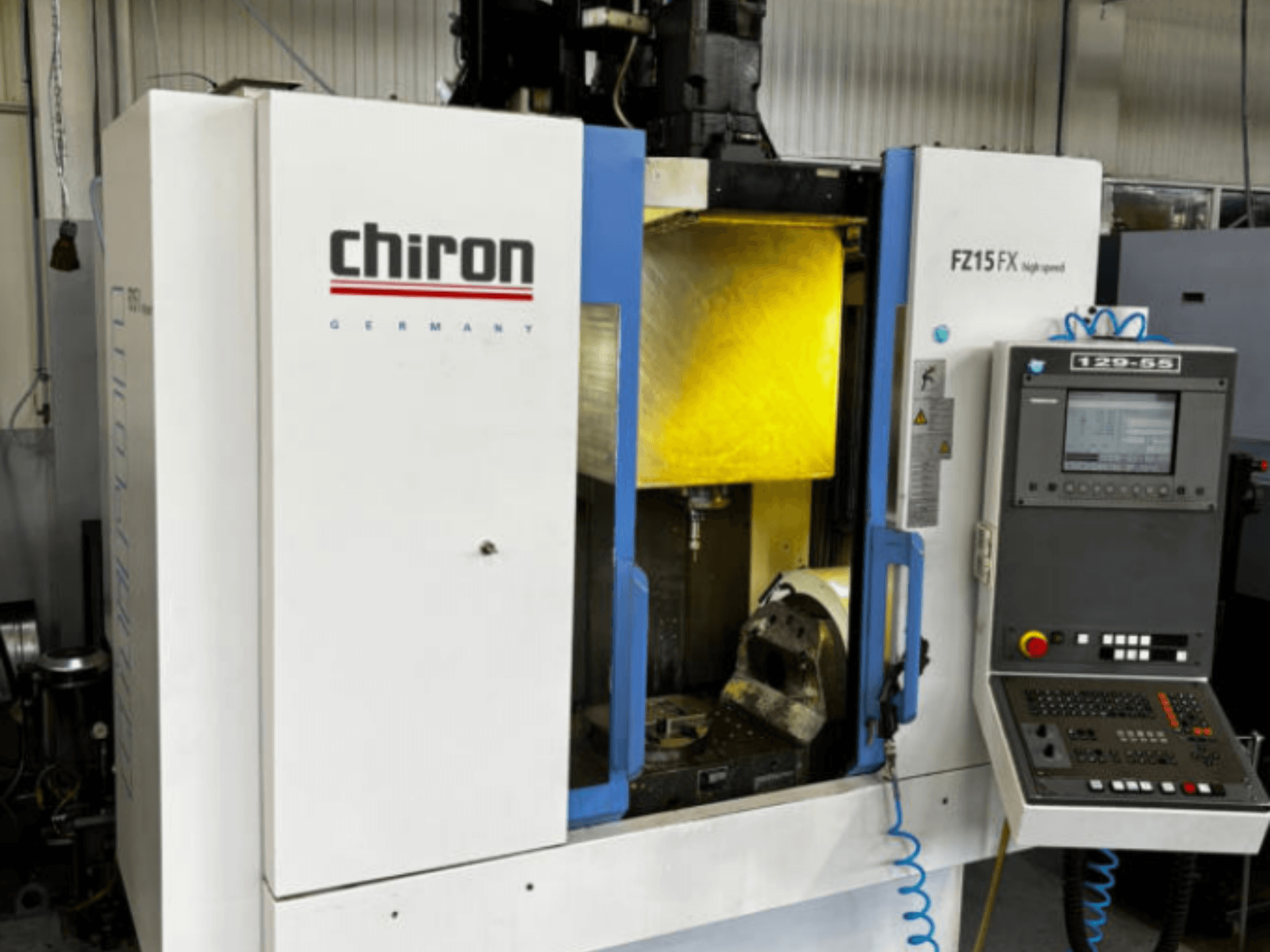CHIRON FZ 15FX verticaal bewerkingscentrum, vooraanzicht, met bedieningspaneel en zichtbaar bewerkingsgebied met gereedschappen.