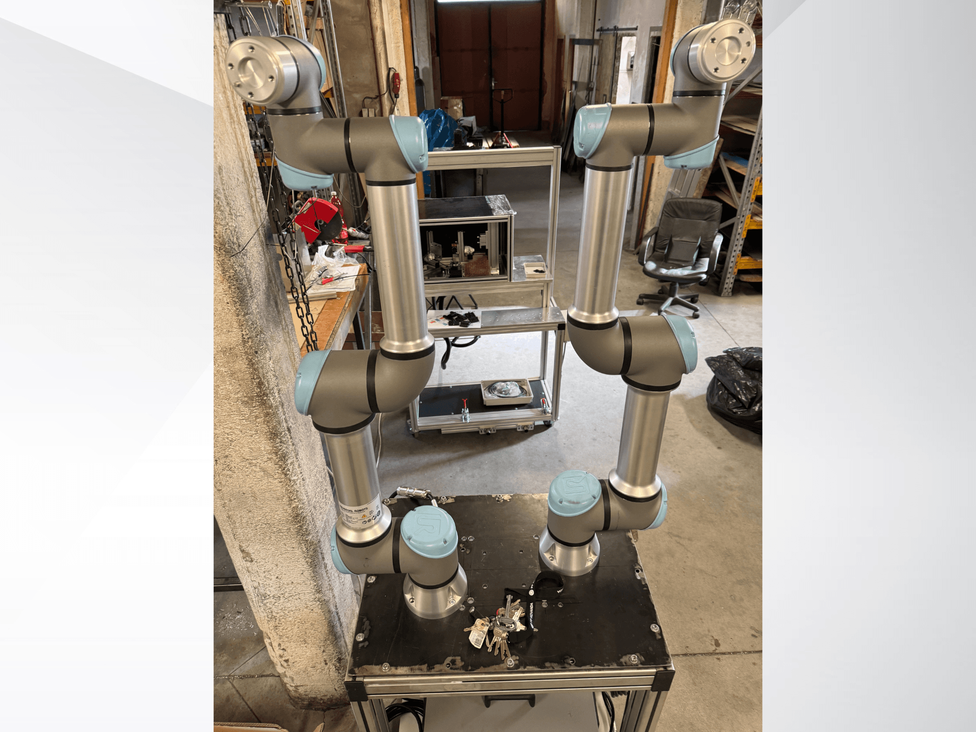 Universal Robots UR5e robotarm in vooraanzicht, met zes gewrichten met grijze en blauwe secties, gemonteerd op een zwart platform.