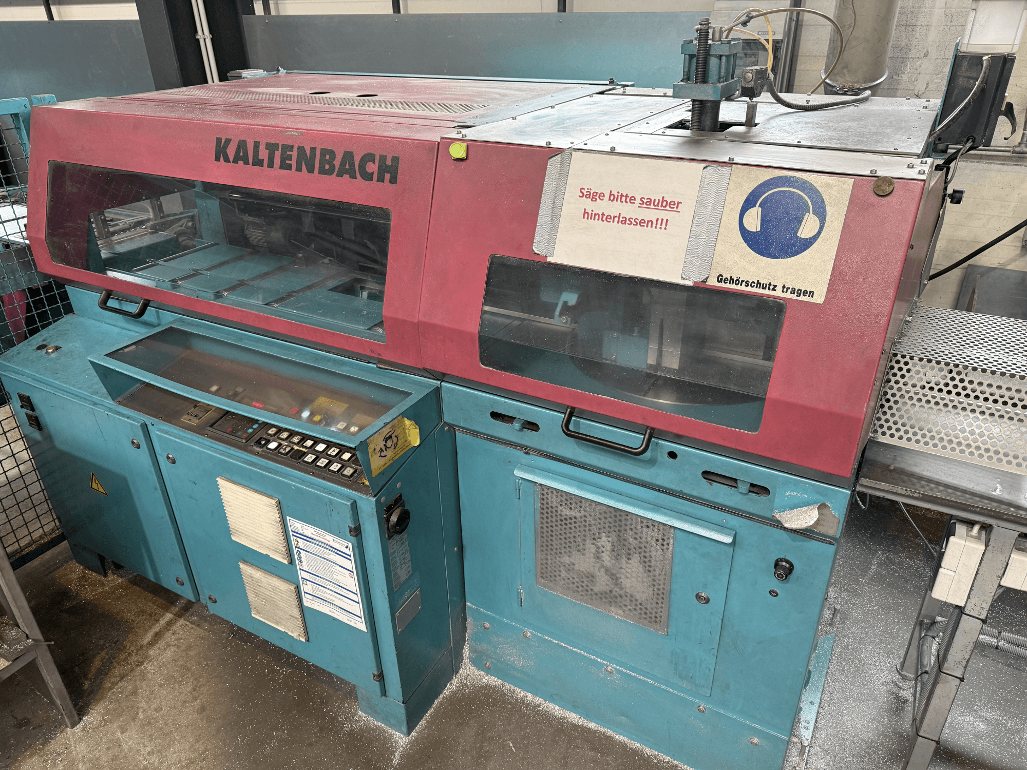 KALTENBACH industriële snijmachine, vooraanzicht, met bedieningspaneel en veiligheidsteken voor gehoorbescherming.