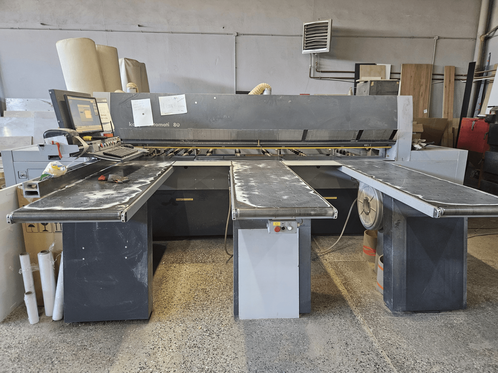 KAPPA Automati 80 machine, vooraanzicht, met drie vlakke tafels, bedieningspaneel en verspreid zaagsel op oppervlakken.
