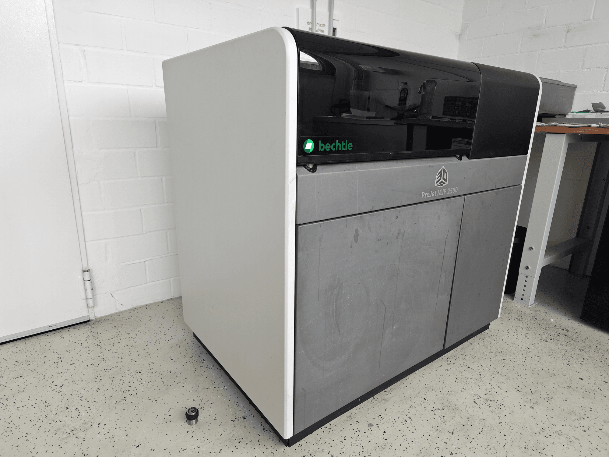 De 3D Systems ProJet MJP 2500 Plus-kunststofprinter in vooraanzicht; heeft een strak ontwerp met een donkere bovenkant en een lichte behuizing.