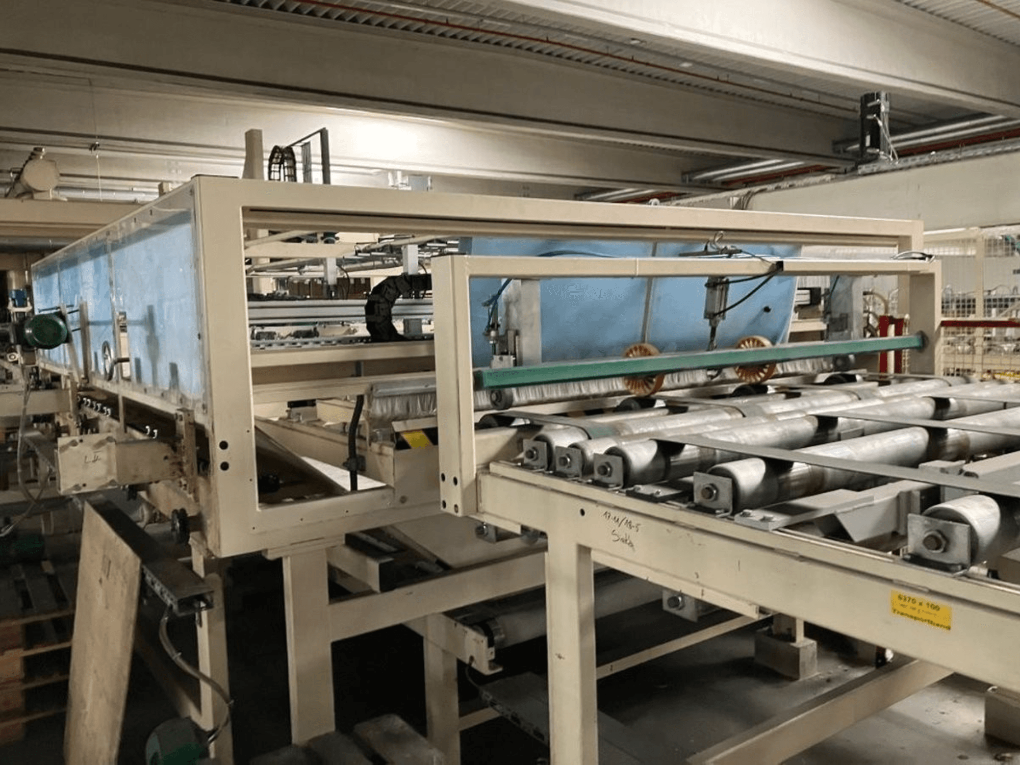 WEMHÖNER KT-F-1E lamineerpers, zijaanzicht, met rollen en bedieningselementen voor materiaalverwerking in een fabrieksomgeving.