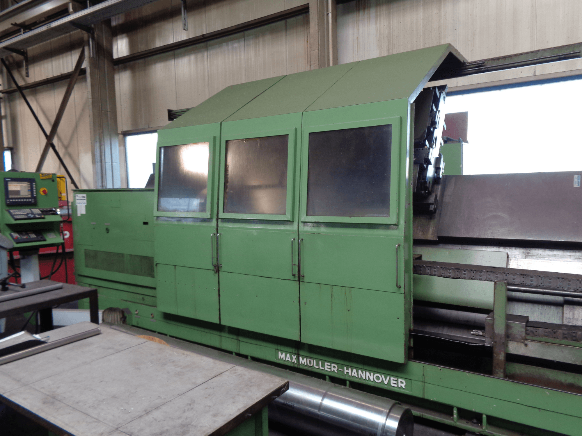 MAX MULLER 3000 draai-freescentrum in groen, zijaanzicht met bedieningspaneel. Het grote bewerkingsgebied en de behuizing met venster zijn zichtbaar.