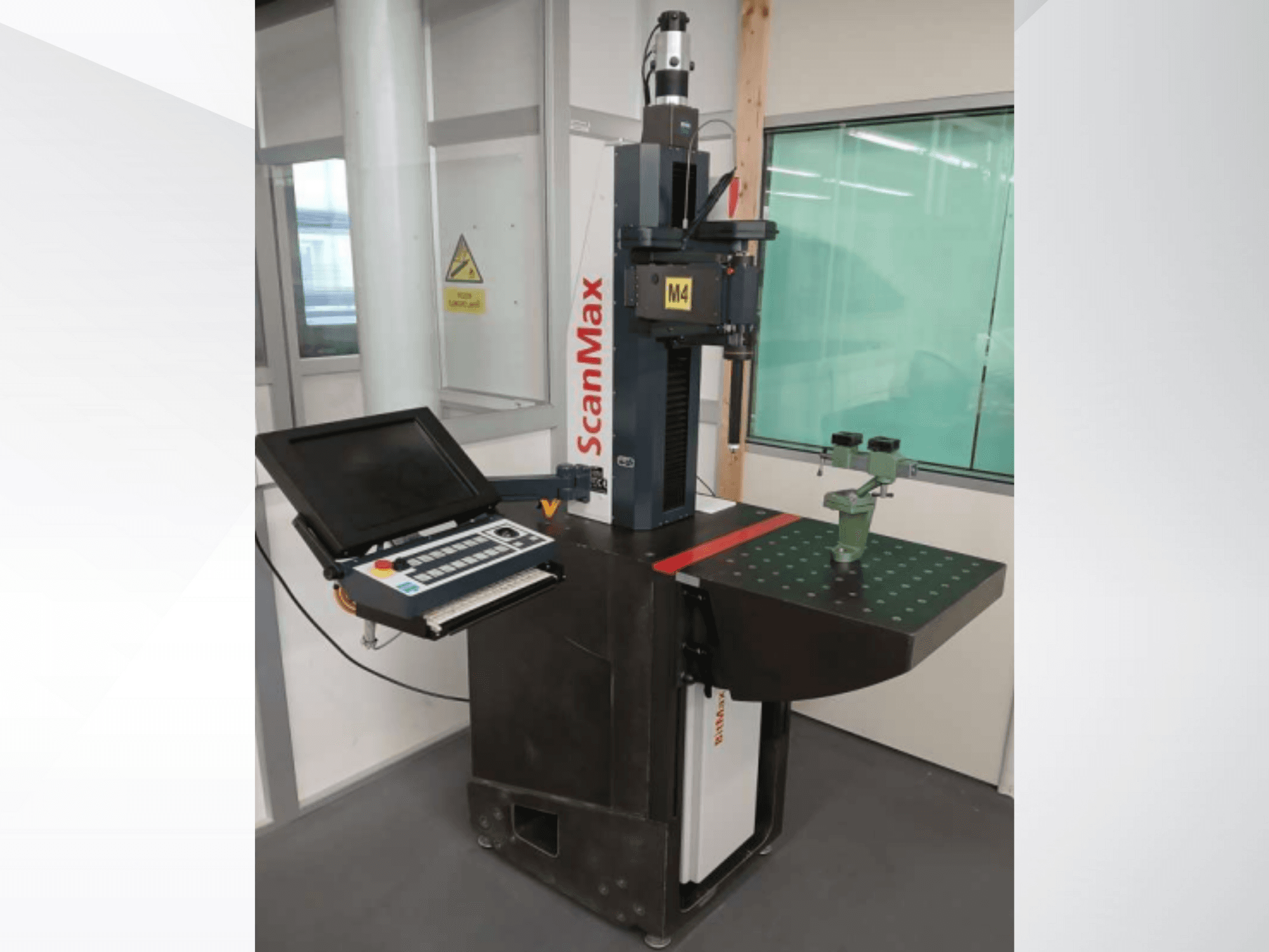 ScanMax M4 meetmachine, vooraanzicht met bedieningspaneel en groene kalibratieopstelling op een gestippelde werktafel.