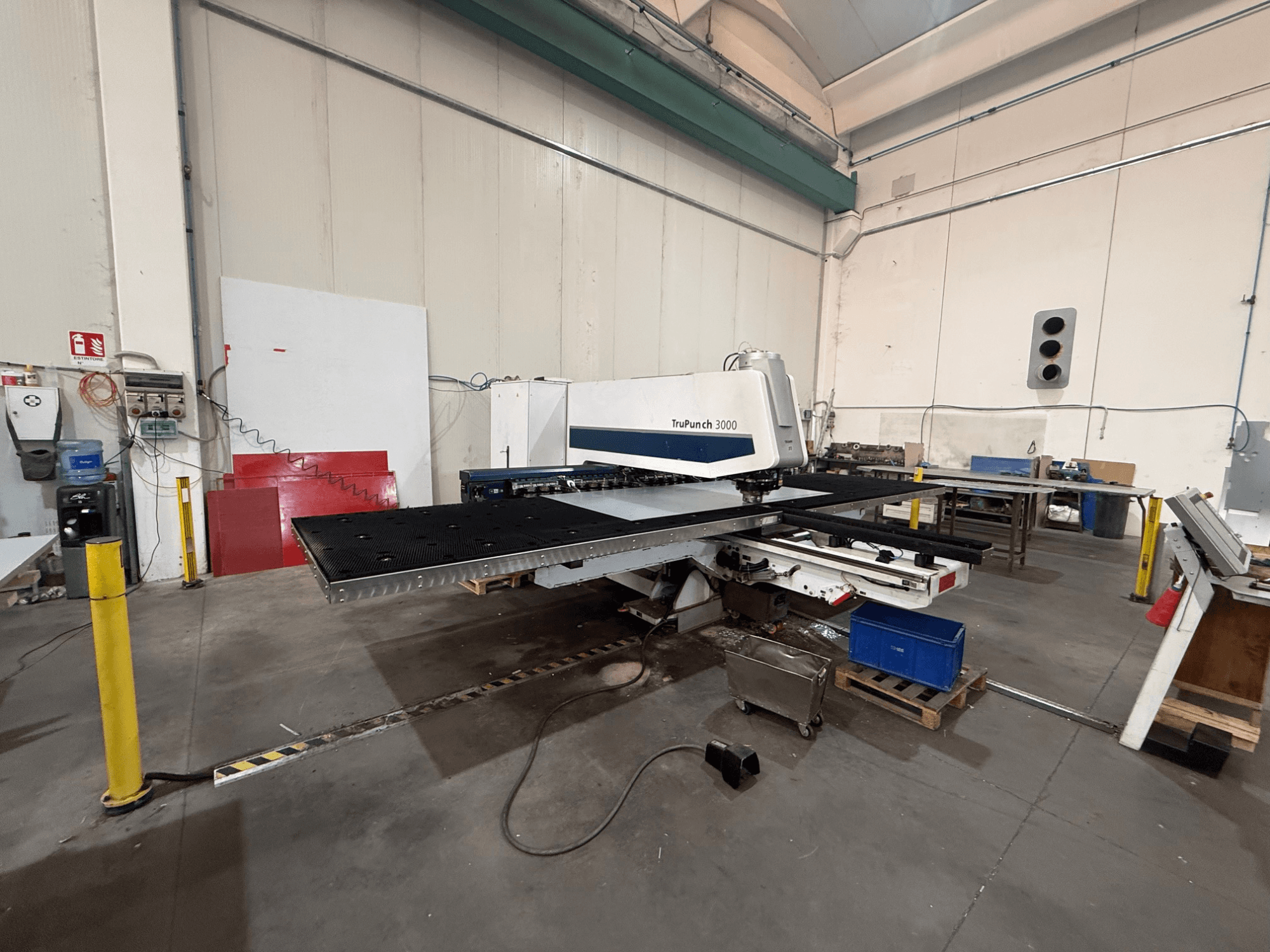 CNC-ponsmachine TRUMPF TruPunch 3000, zijaanzicht, met de ponskop, de grote werktafel en de omliggende werkplaatsomgeving.
