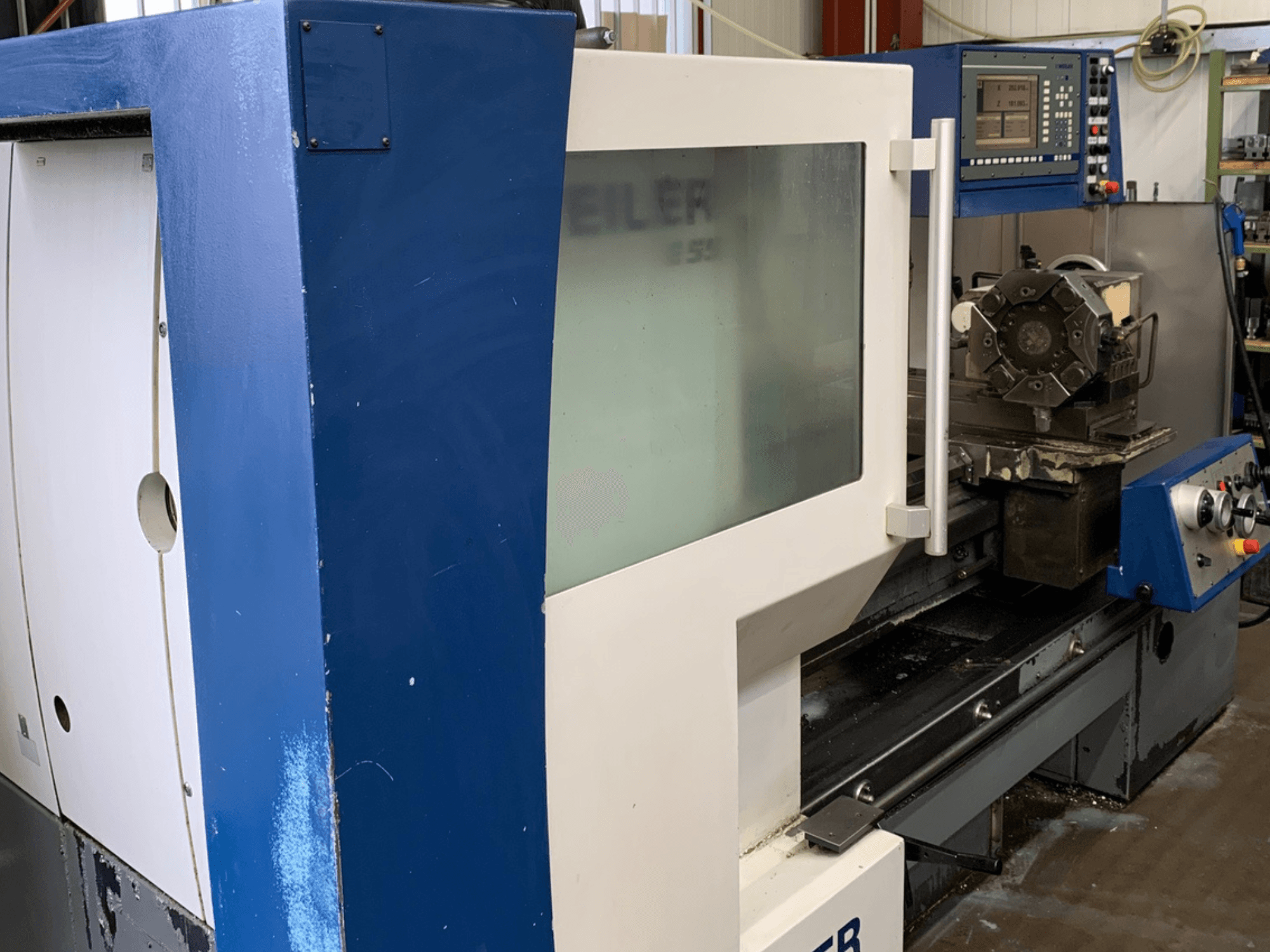 Weiler E55X1000 horizontale draaimachine, zijaanzicht met bedieningspaneel en gereedschapinstelling.