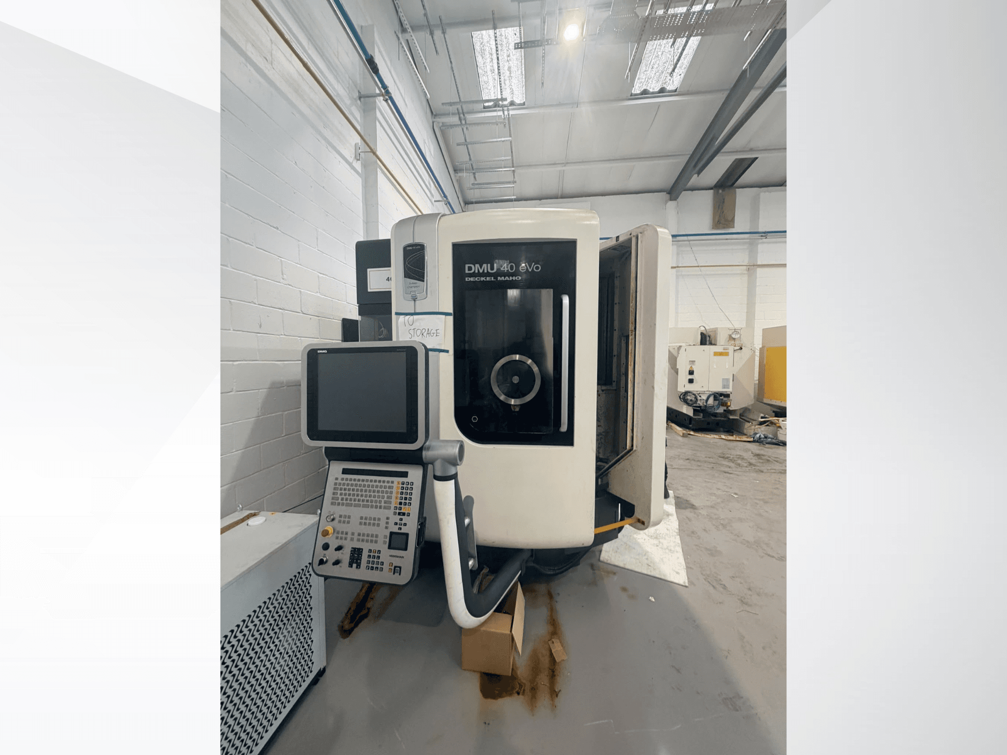 DMG DMU 40 evo verticaal bewerkingscentrum, vooraanzicht, met weergave van het bedieningspaneel en het spindelgedeelte, met het werkgebied op de achtergrond.