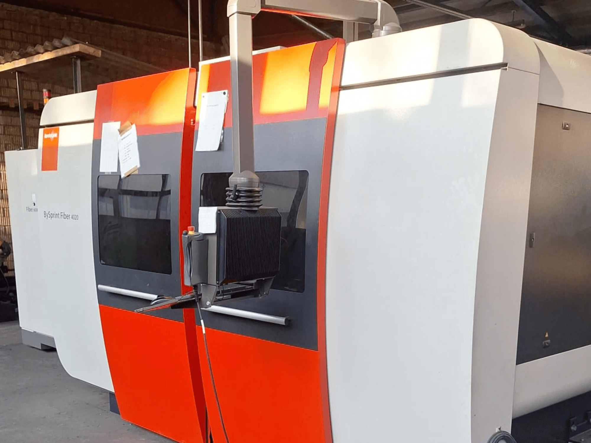BySprint Fiber 4020 lasersnijmachine, zijaanzicht, met een rood-witte buitenkant, gedetailleerd bedieningspaneel zichtbaar.