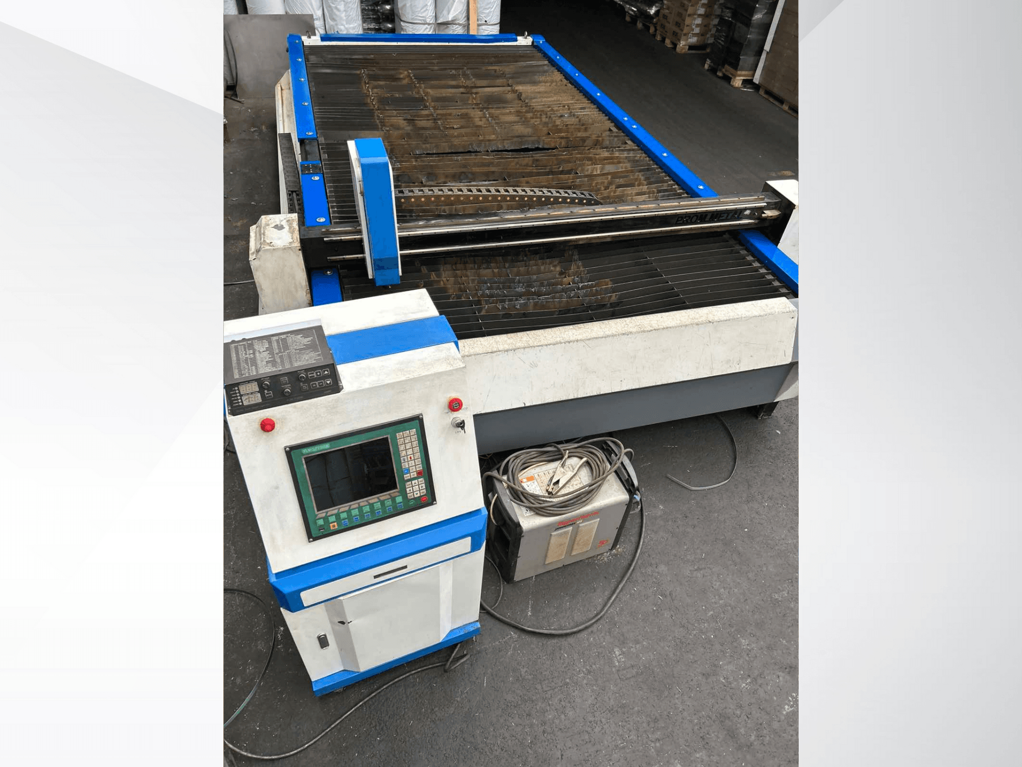 CNC-plasmasnijmachine met bedieningspaneel, vooraanzicht, met blauwe accenten en kabels op de vloer.