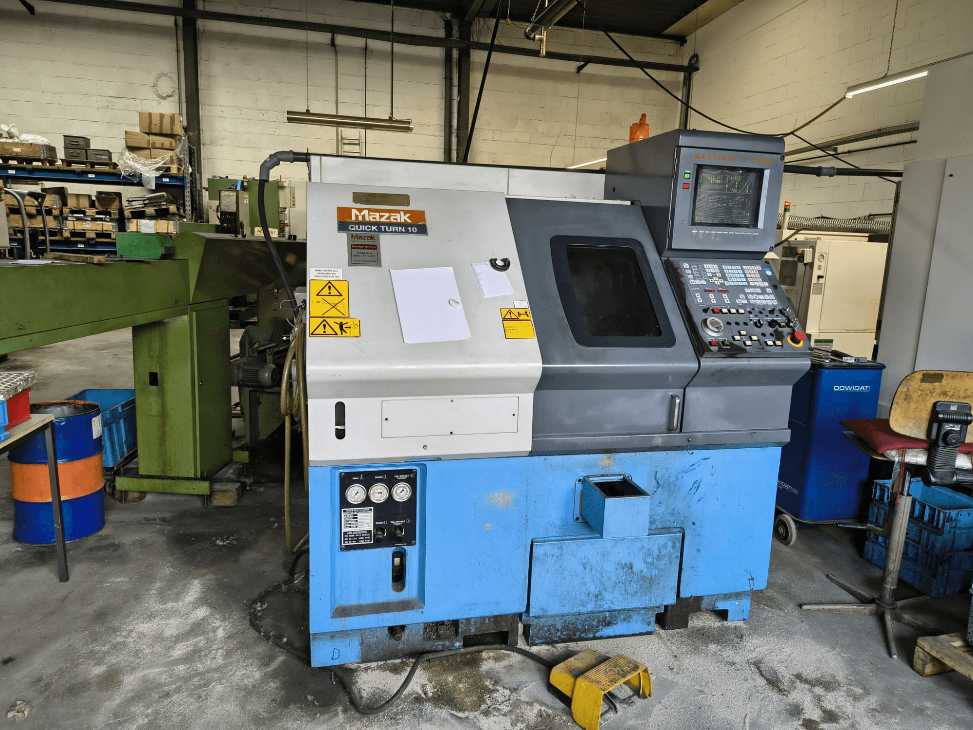 Mazak Quick Turn 10 horizontale draaimachine, vooraanzicht, met zichtbaar bedieningspaneel en veiligheidsstickers.