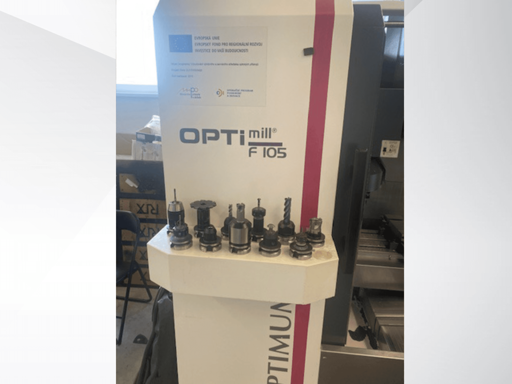 Vooraanzicht van het verticale bewerkingscentrum Optimum Optimill F105, met aan de zijkant diverse gemonteerde gereedschappen.