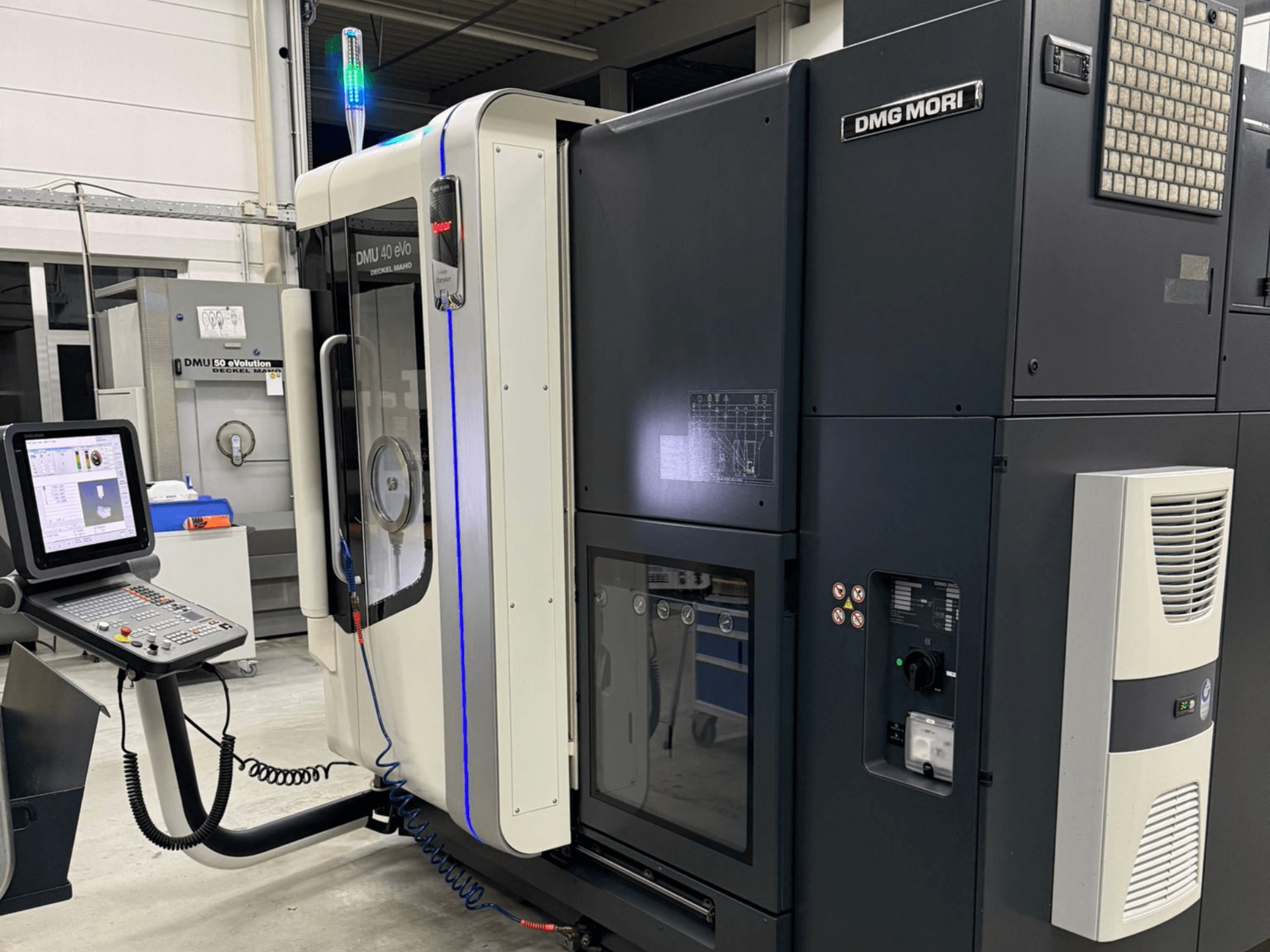 DMG MORI DMU 40 eVo machine, vooraanzicht met bedieningselementen, LED indicatoren en een slank ontwerp dat industriële kenmerken benadrukt.