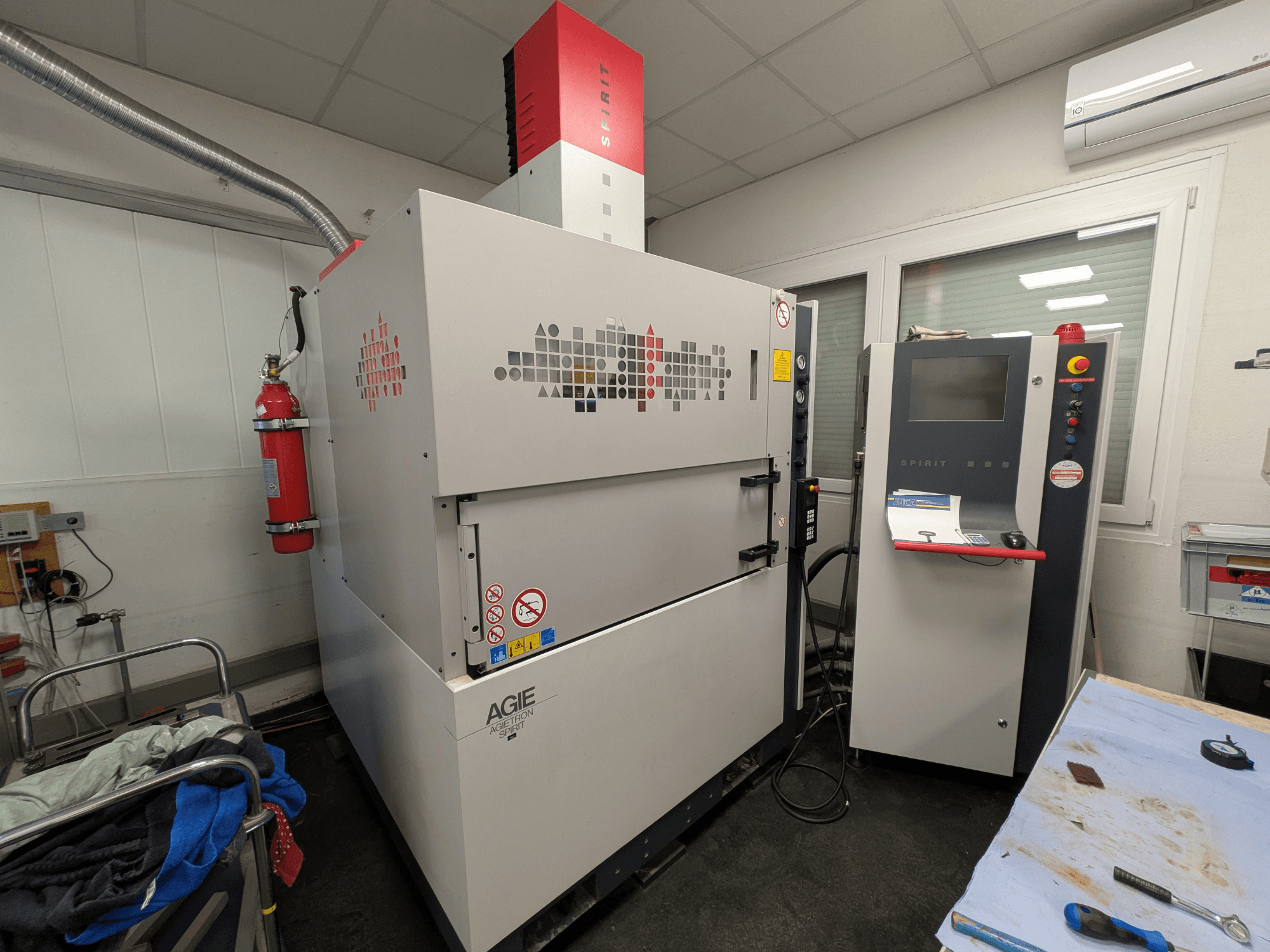 Zaagvonkmachine AGIE AGIETRON SPIRIT 3, zijaanzicht, met het bedieningspaneel en de brandblusser.