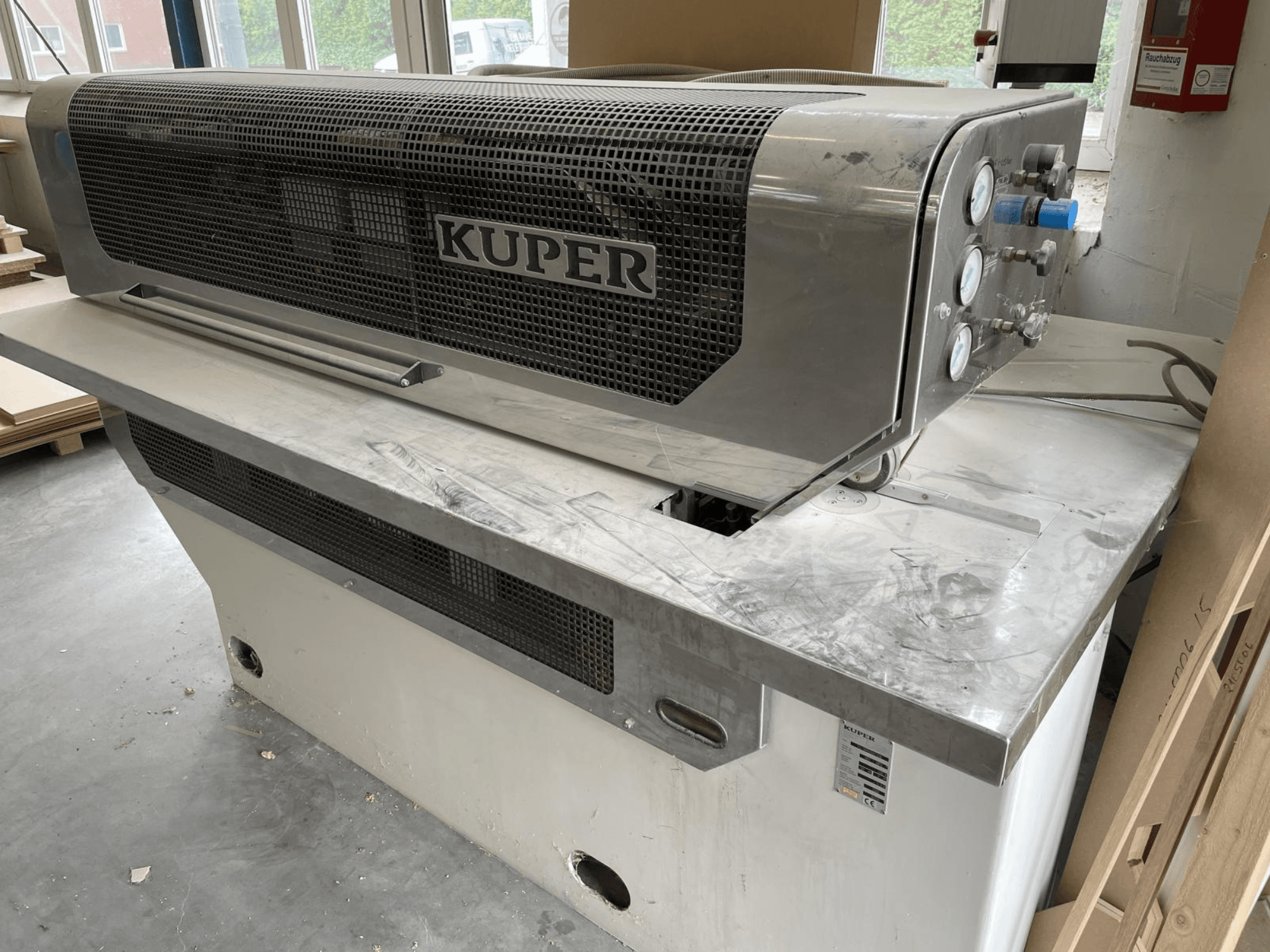 Fineer guillotine KUPER FLI, vooraanzicht, met een roestvrijstalen behuizing, meters en een schone snijzone op een werkbank.