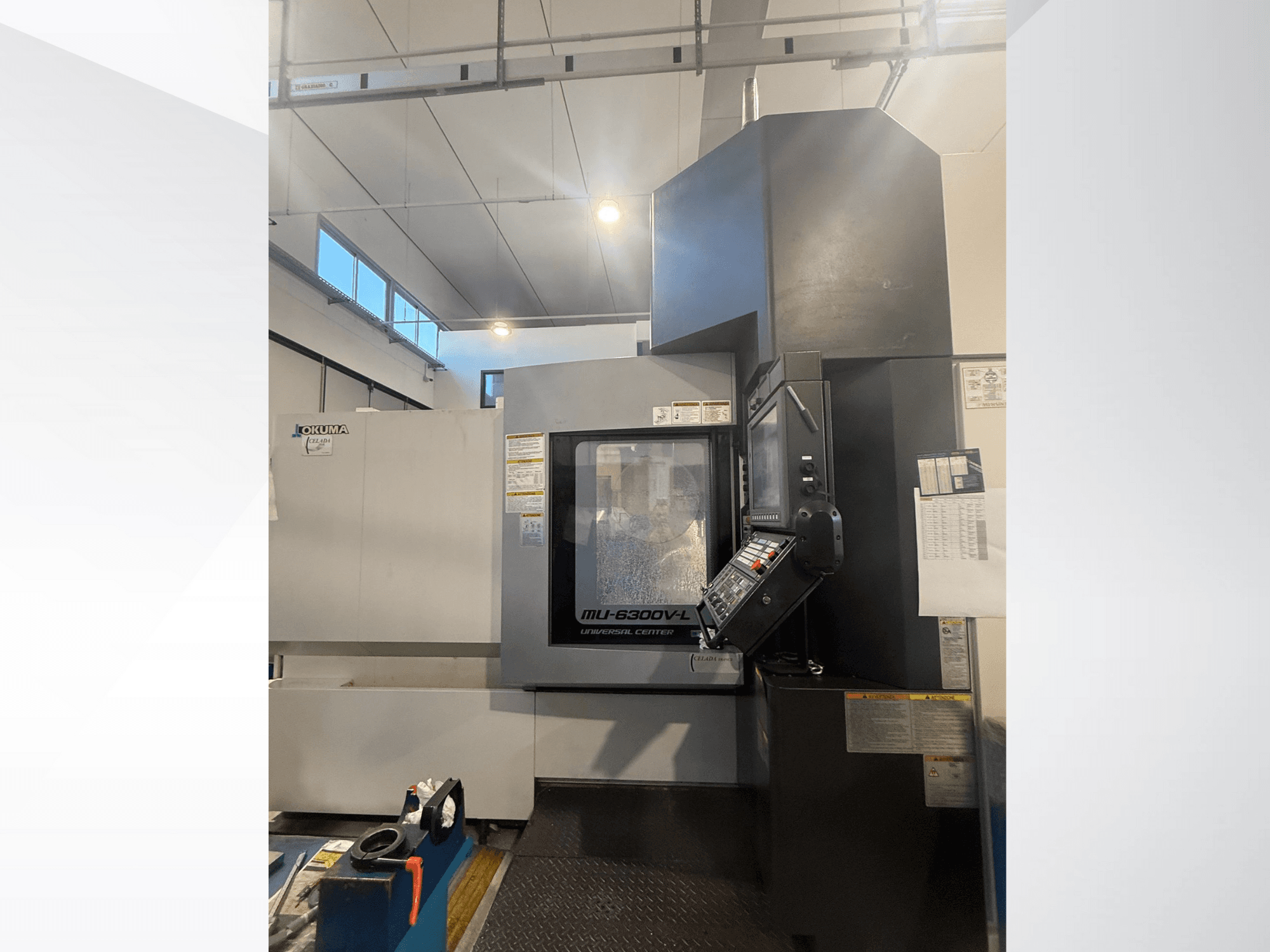 Okuma MU-6300V-L CNC machine gezien vanaf de voorkant, met het bedieningspaneel en de veiligheidslabels.