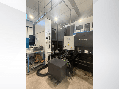 Okuma bewerkingscentrum met ConSep unit, zijaanzicht, weergave van bedieningselementen en industriële opstelling, inclusief bak voor metaalspanen.