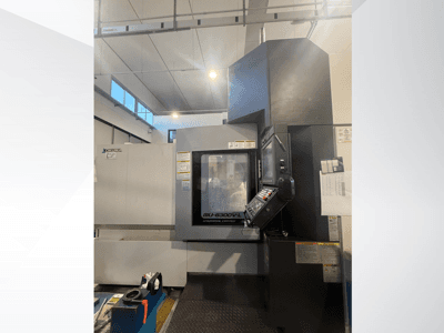 Okuma MU-6300V-L CNC machine gezien vanaf de voorkant, met het bedieningspaneel en de veiligheidslabels.