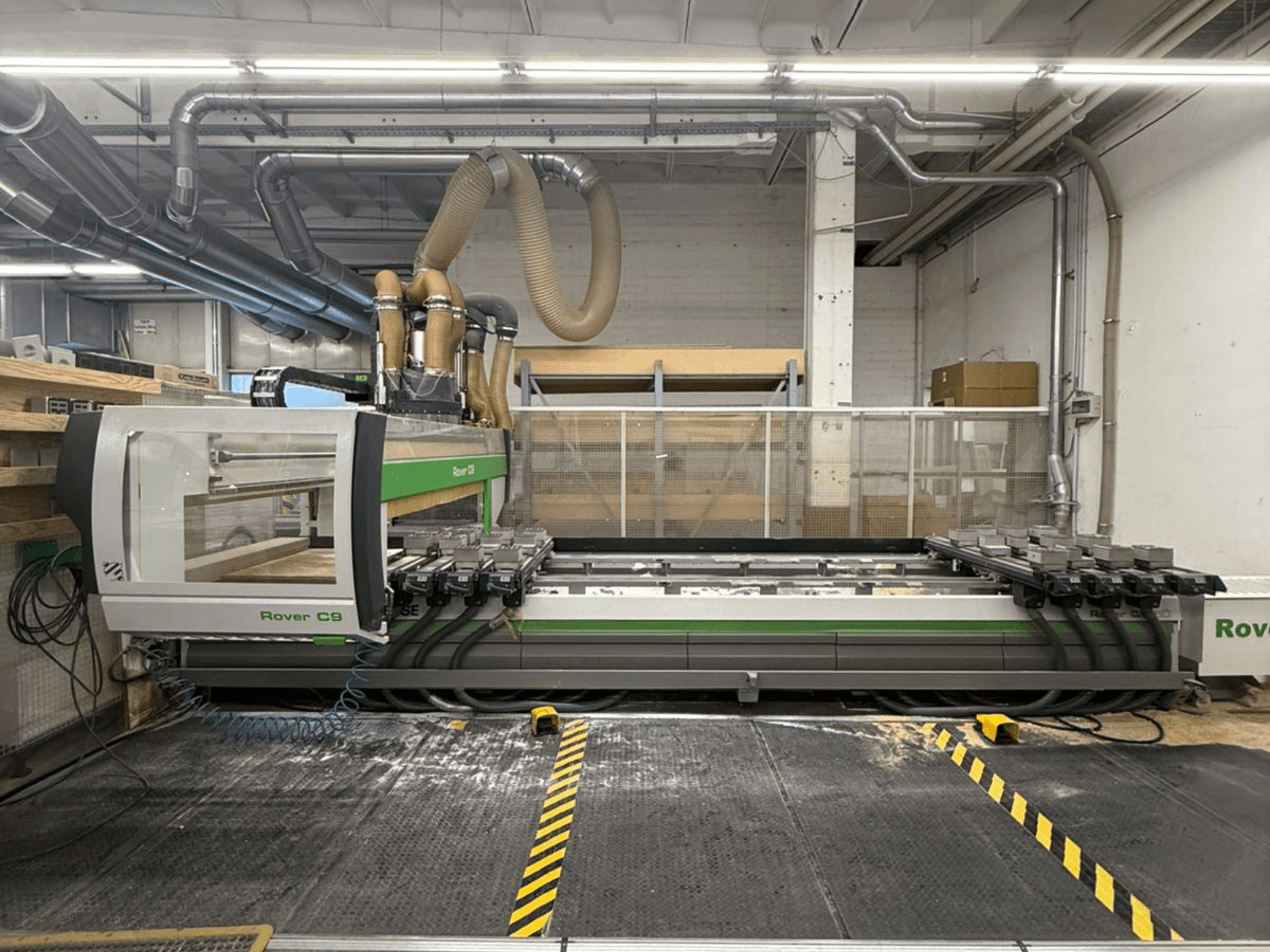 Rover C9 CNC machine in een werkplaats, vooraanzicht, met meerdere snijkoppen en zichtbaar stofafzuigsysteem.