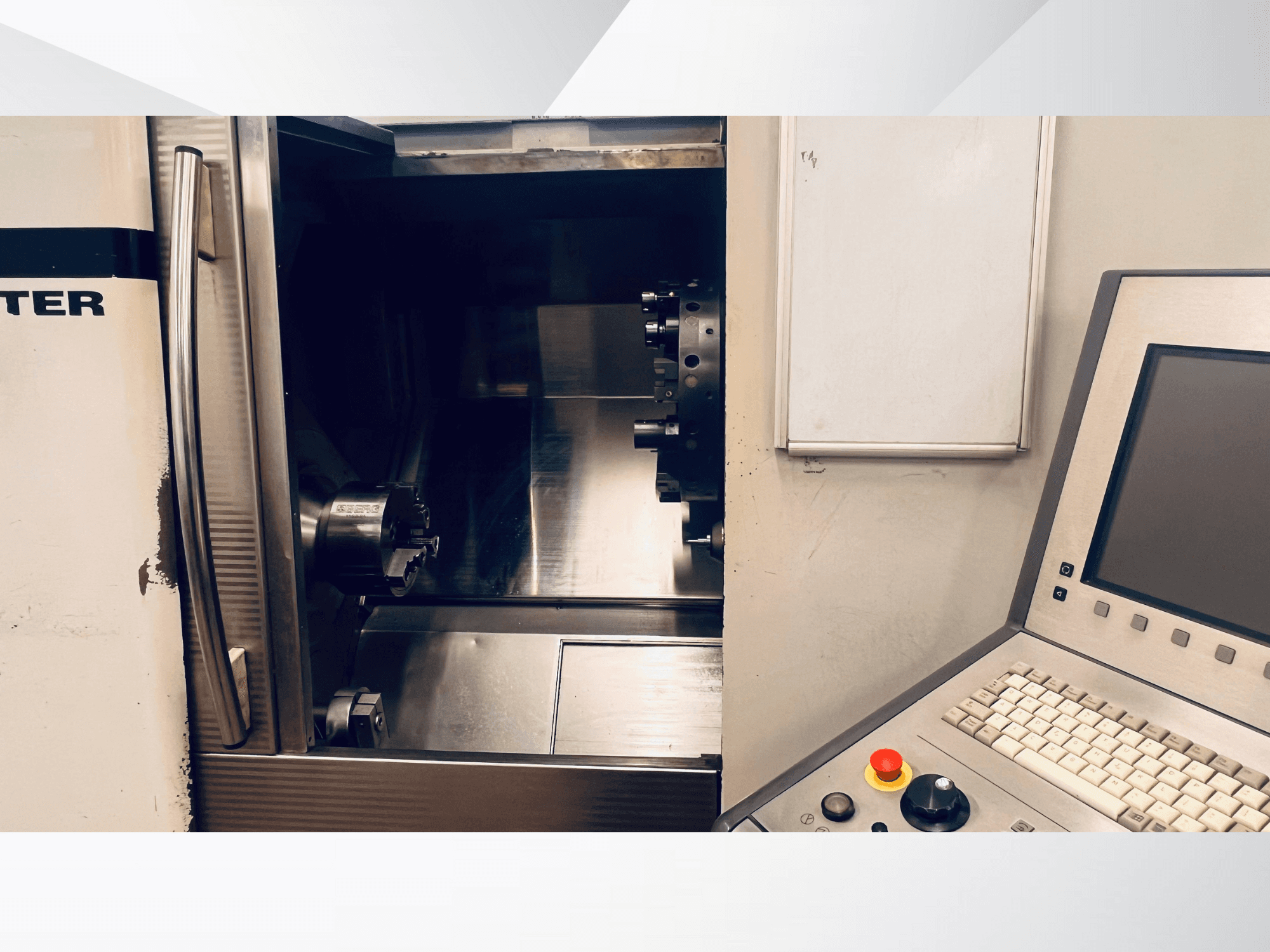 Vooraanzicht van de CNC machine met de open kamer en het bedieningspaneel met toetsenbord en noodstopknop.