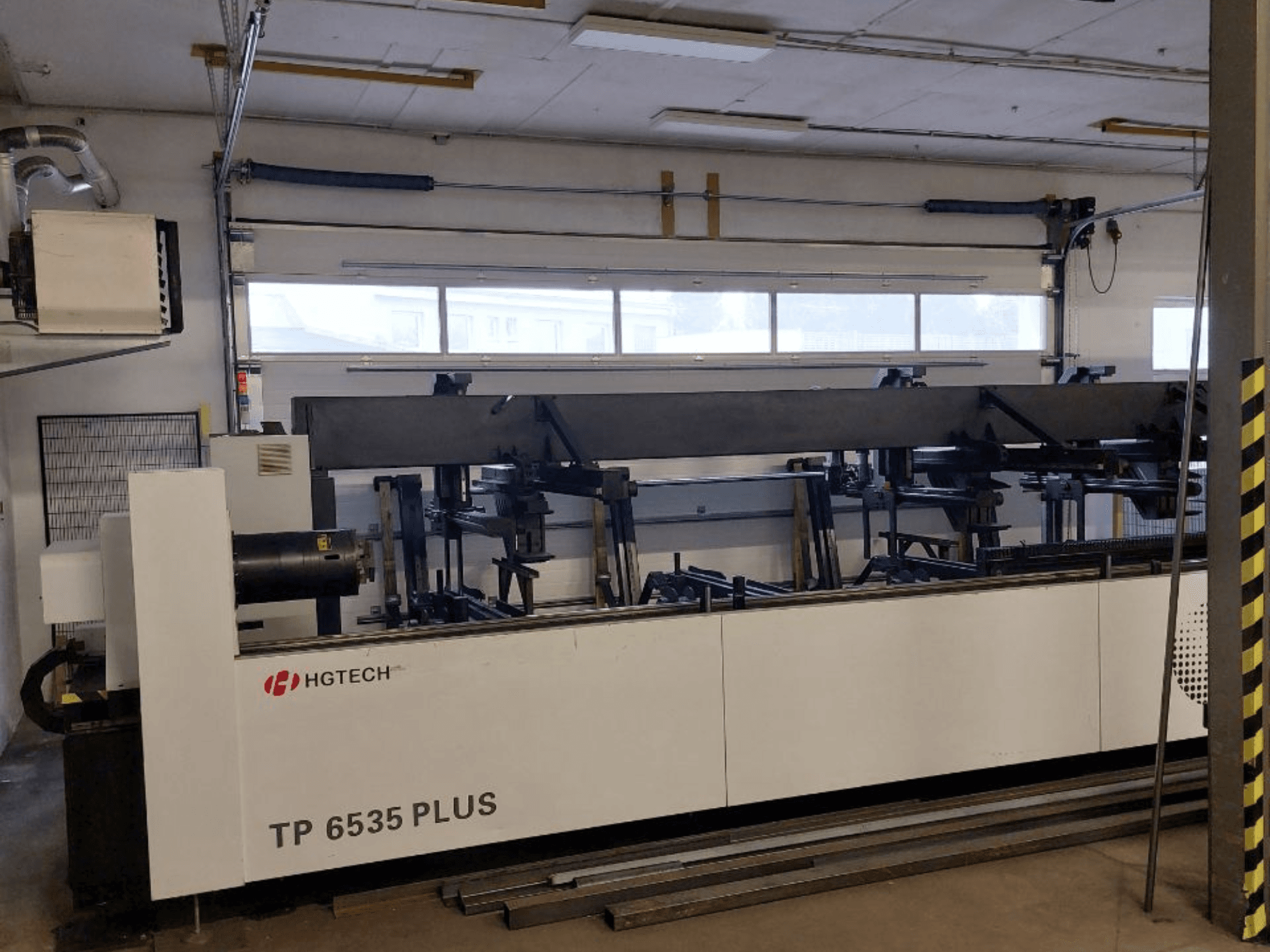 HGTECH TP 6535 PLUS, vooraanzicht van een grote industriële machine met meerdere armen voor precisiefabricage, opgesteld in een werkplaats.