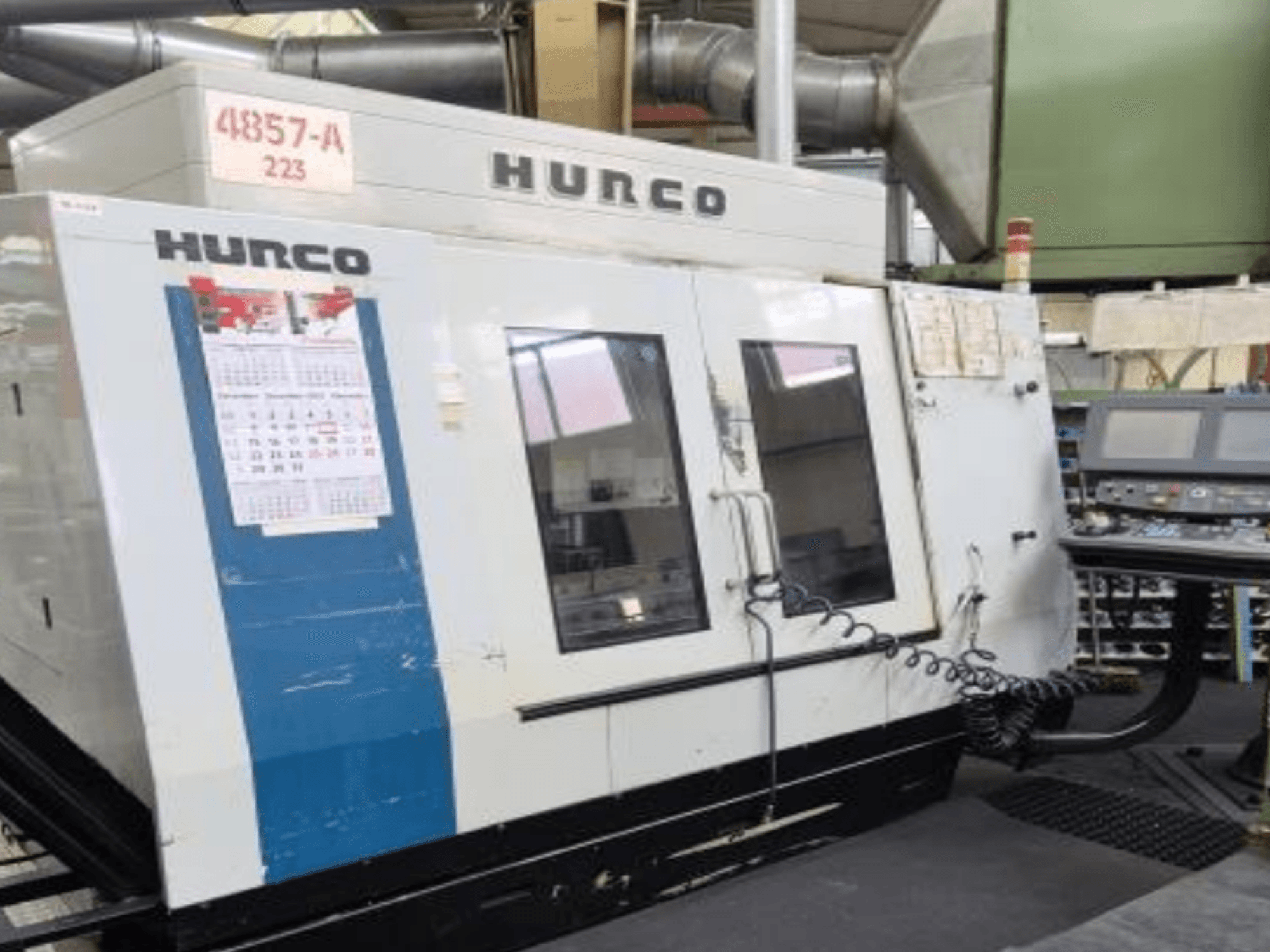Hurco VMX 42 verticaal bewerkingscentrum in vooraanzicht, met bedieningspaneel, kalender en metalen buitendetails.