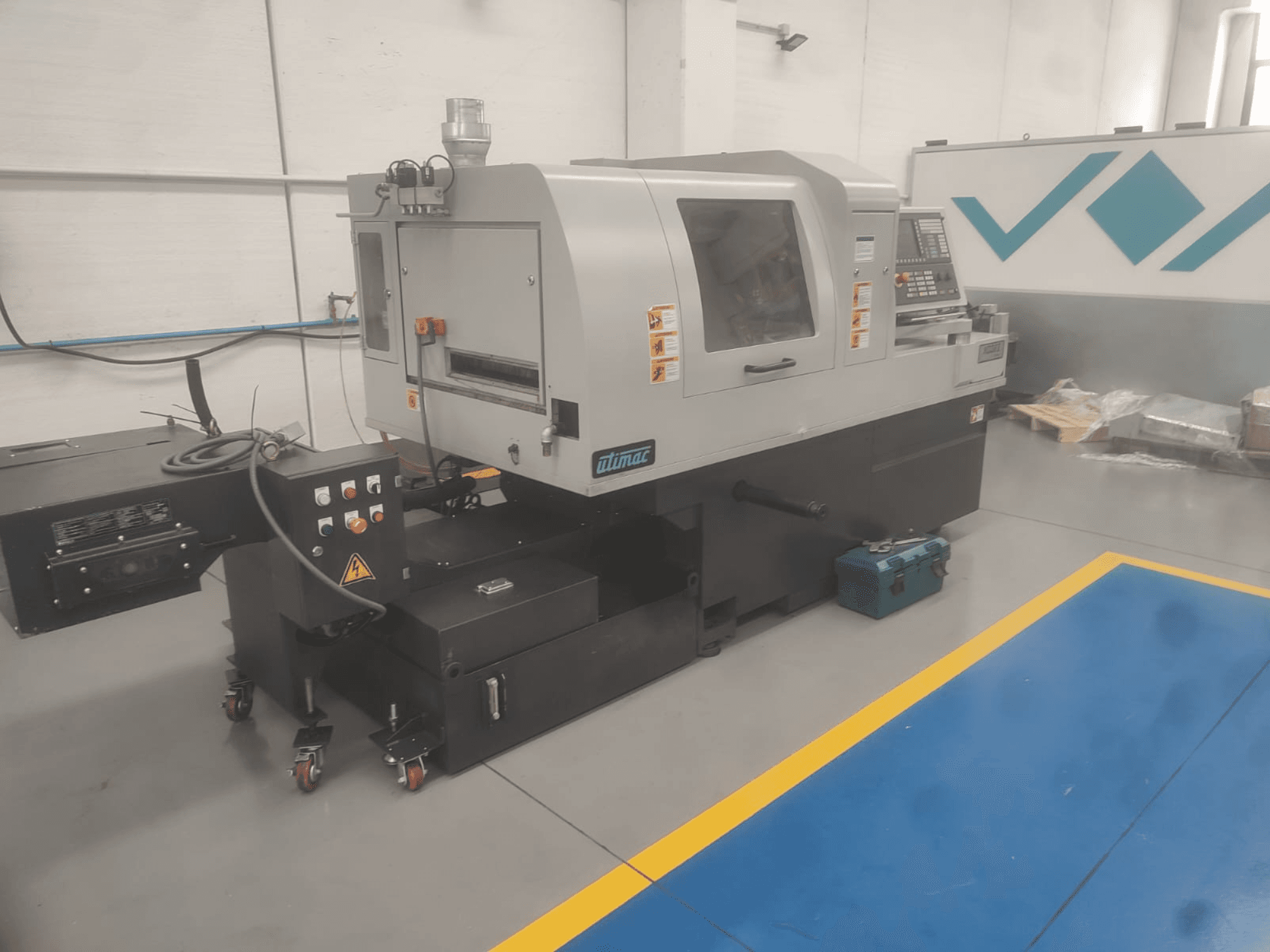 UTIMAC ISOLA XD 38 II Zwitserse draaimachine, vooraanzicht, met bedieningspaneel en verrijdbaar onderstel voor mobiliteit.