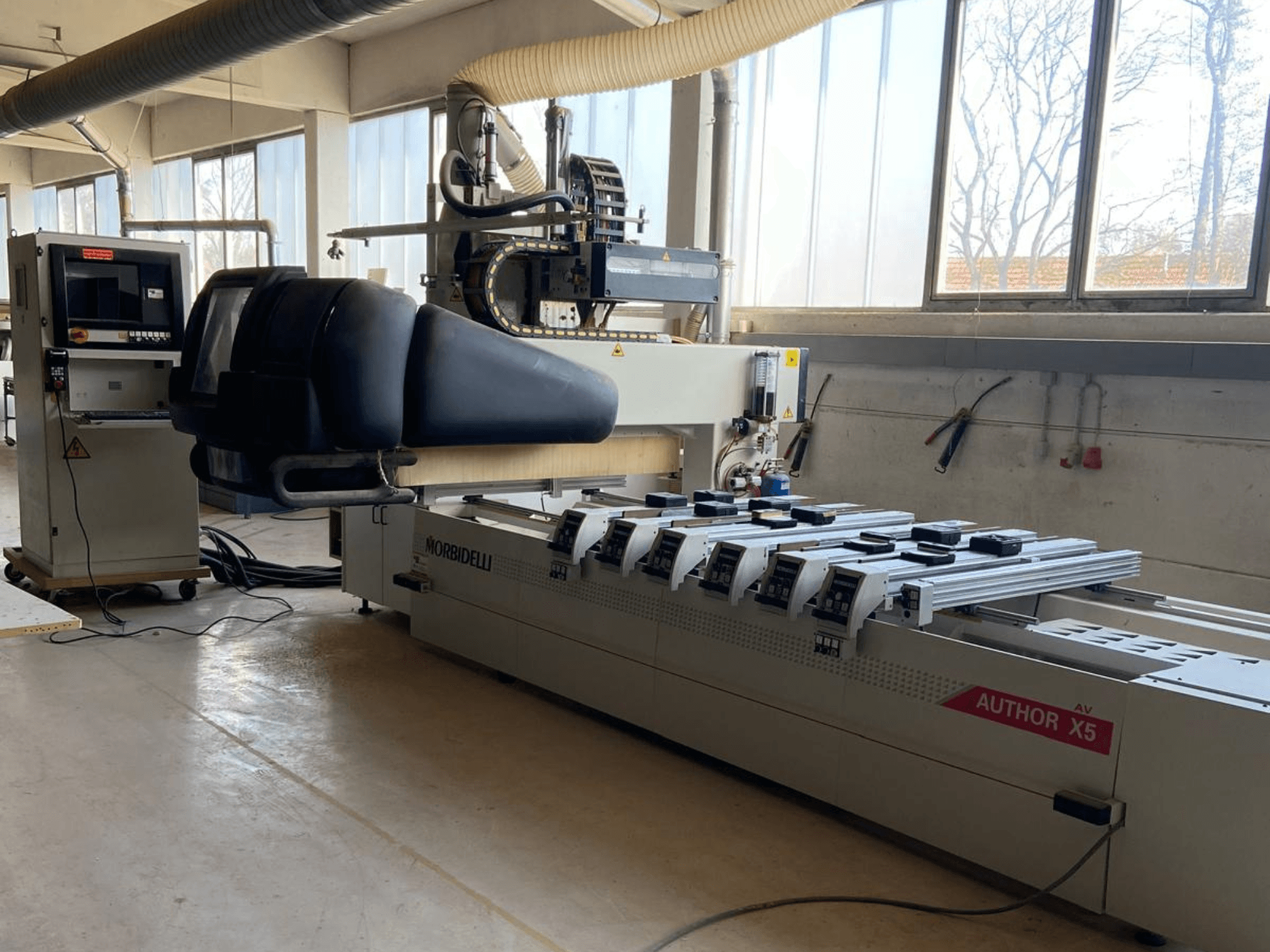CNC houtbewerkingscentrum MORBIDELLI Author X5 in een werkplaats, met het bedieningspaneel en het bewerkingsgebied in zijaanzicht.