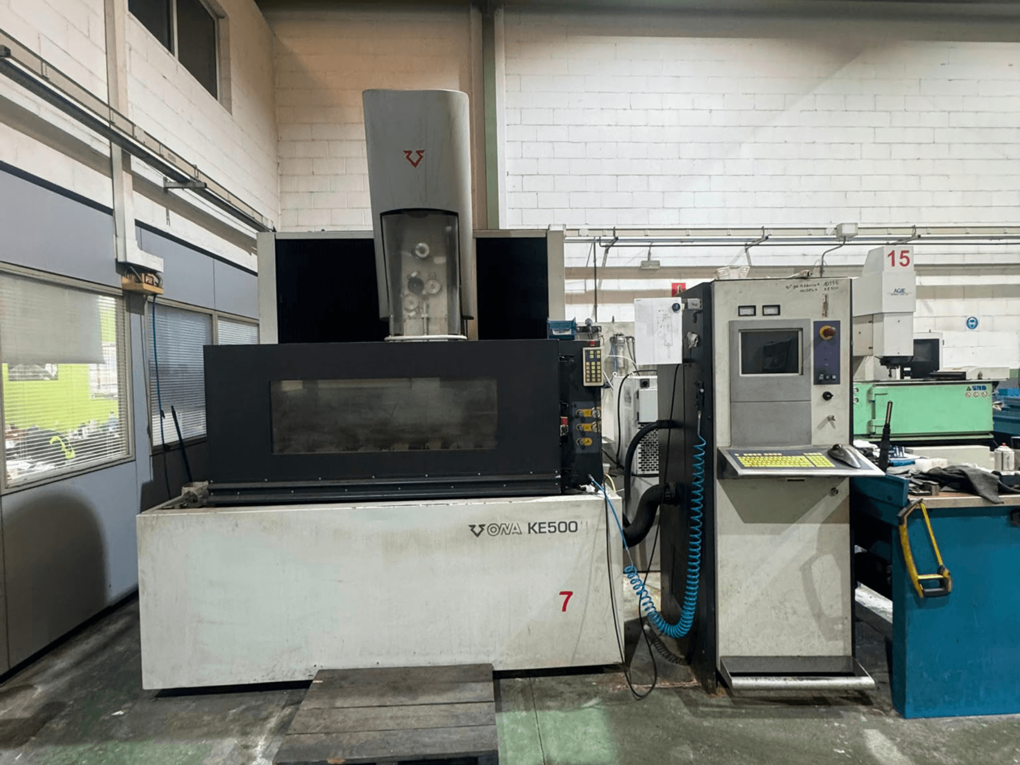 ONA KE500 draadvonkmachine in vooraanzicht, met een bedieningspaneel, snijgebied en centrale koelvloeistofspil.