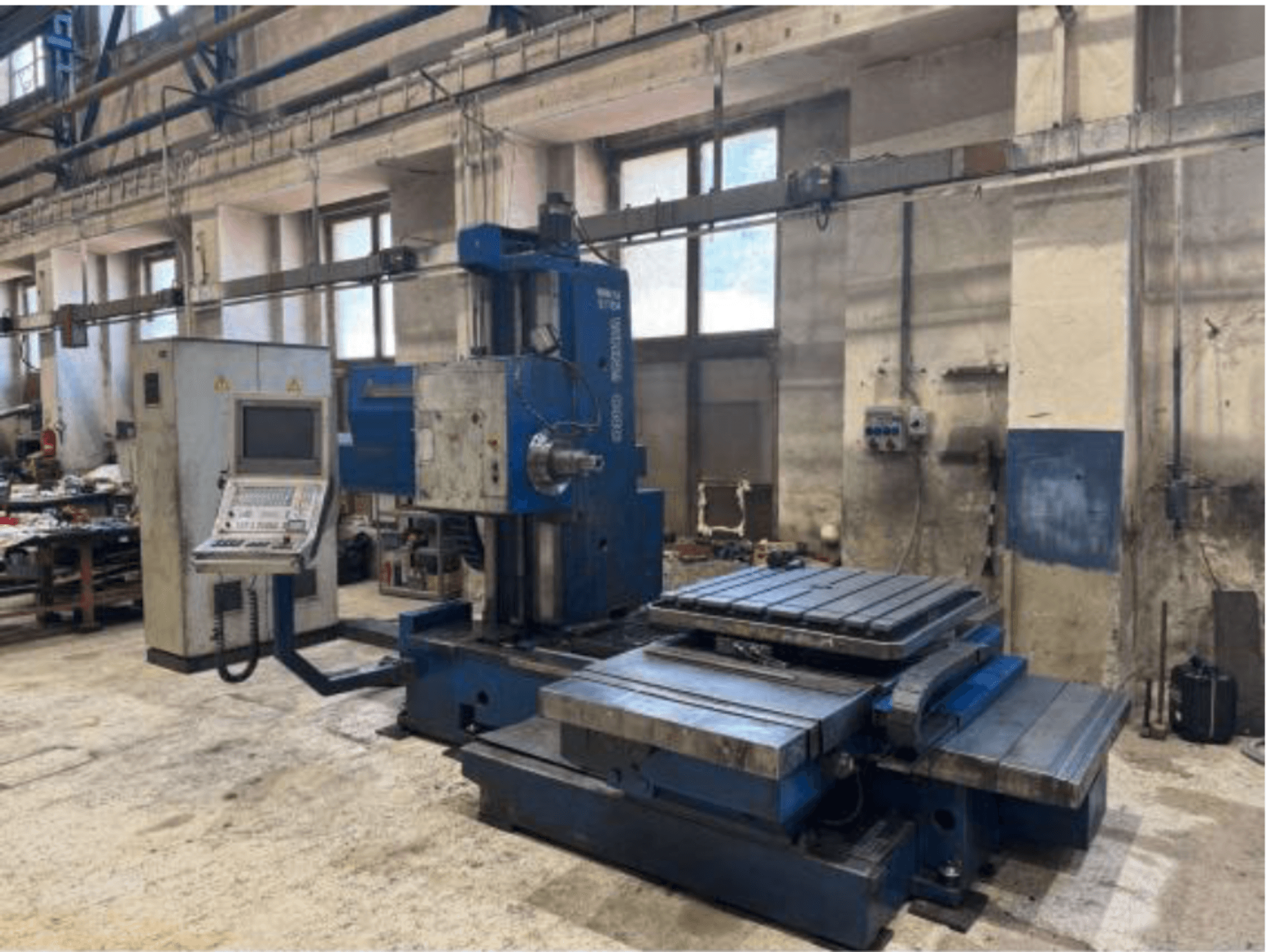 TOS WHN 9 B CNC-boormachine in vooraanzicht, met een bedieningspaneel en een grote werktafel, geplaatst in een werkplaatsomgeving.
