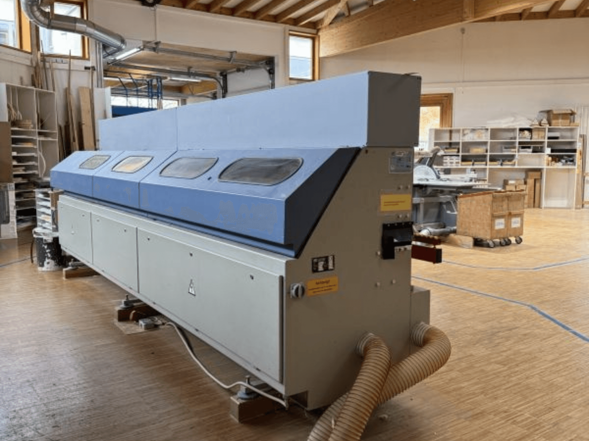 OTT Pacific V6-F kantenbewerker in zijaanzicht; heeft een lange blauwe bovenkant en bedieningspaneel met slangbevestiging.