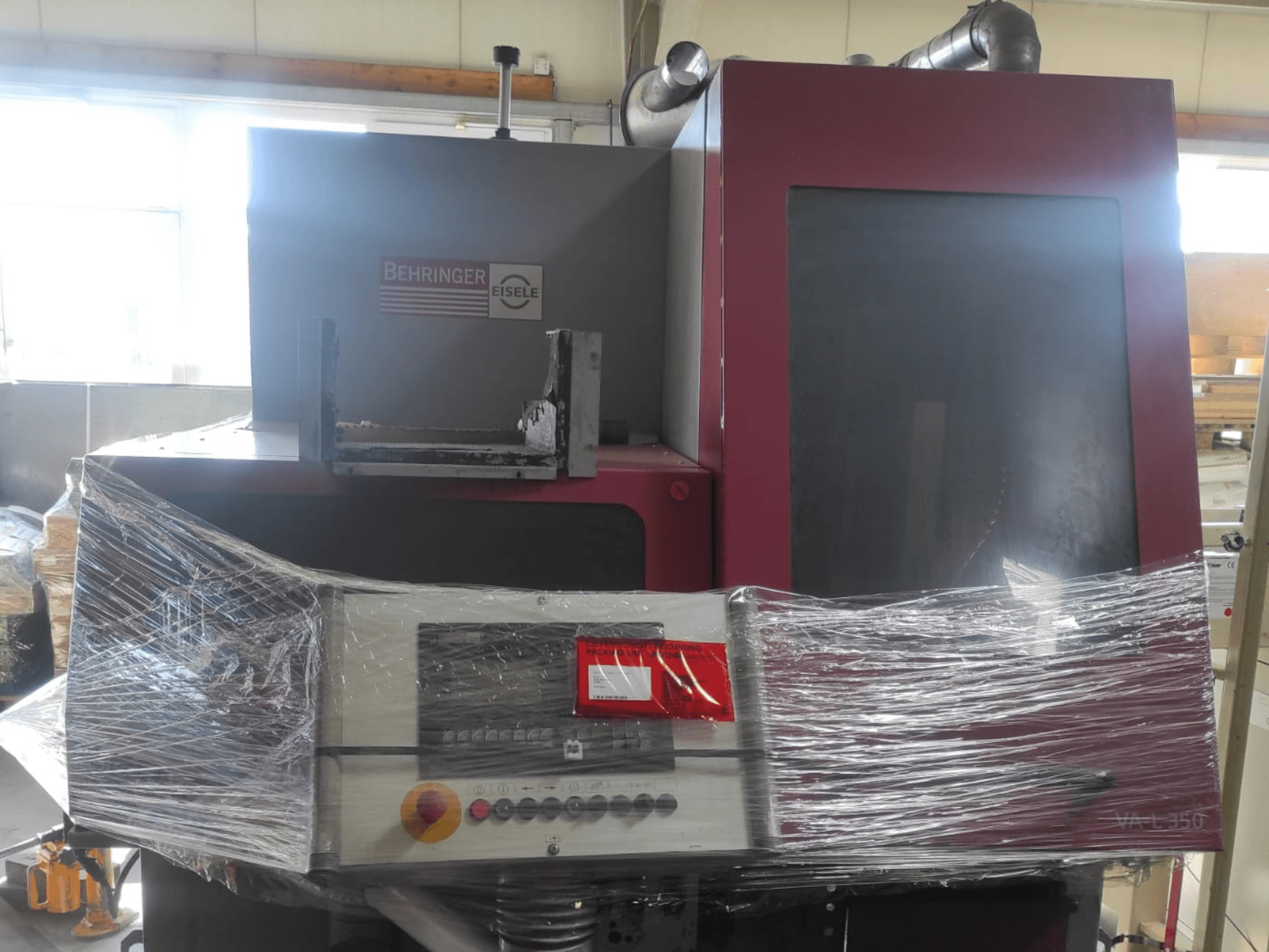 Behringer Eisele VA L 560 machine, vooraanzicht, verpakt in plastic, met bedieningspaneel en knoppen zichtbaar.