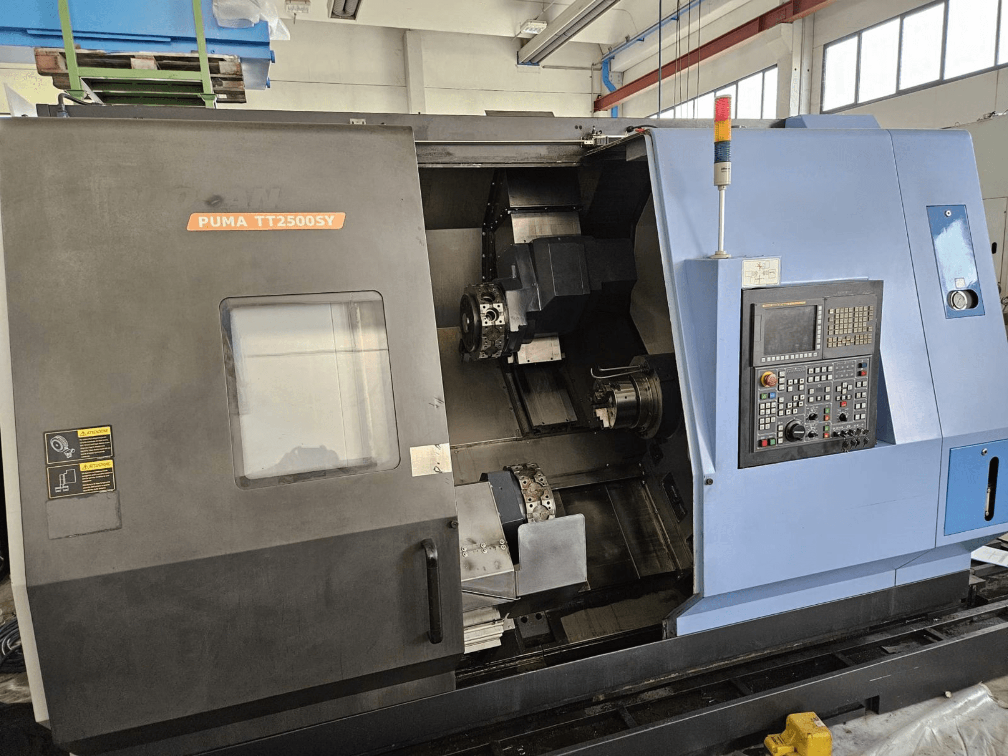 DOOSAN PUMA TT2500SY meerassige draaimachine, vooraanzicht met het bedieningspaneel en details van het interieur van de machine.