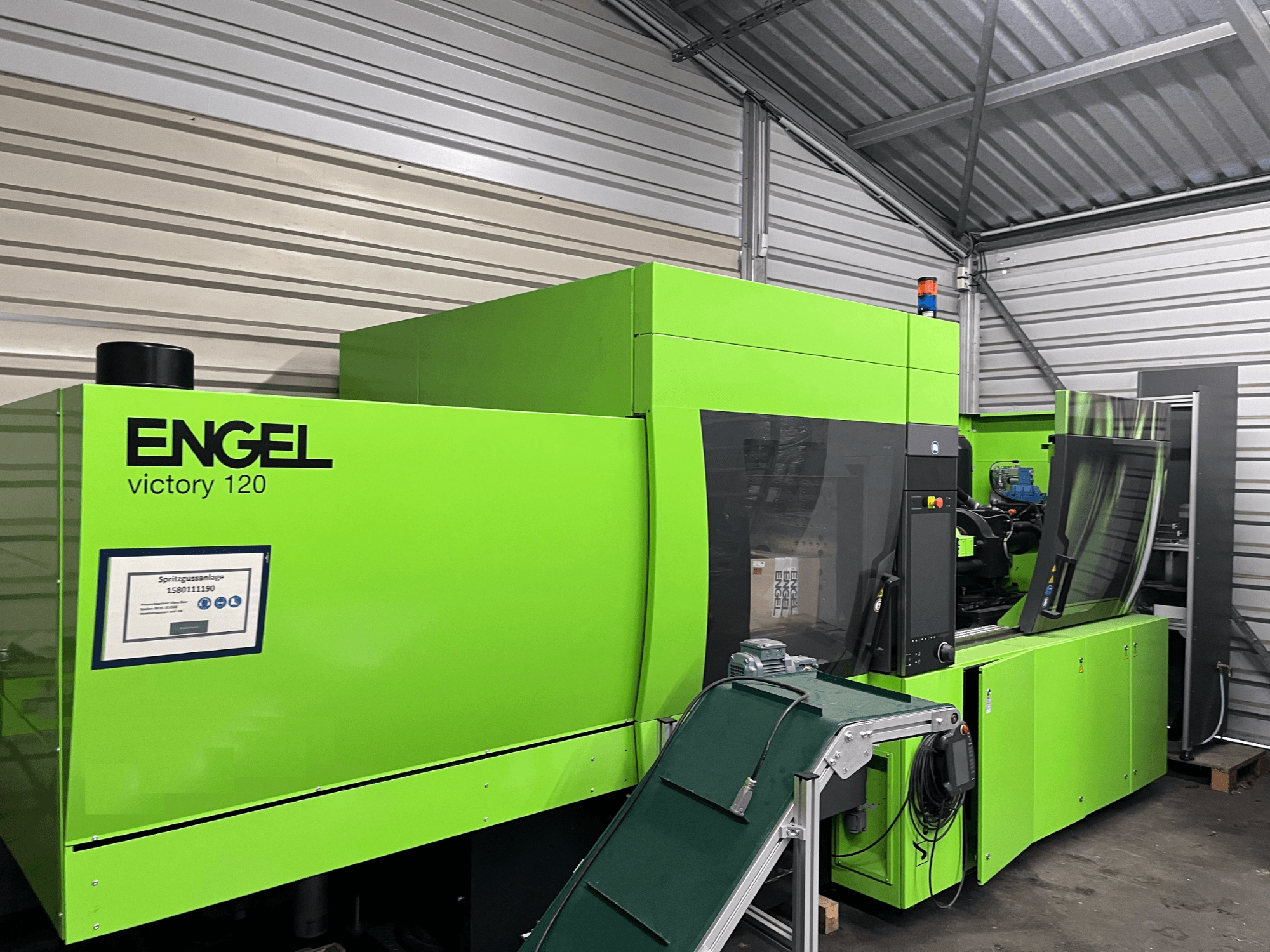 Groene Engel Victory 120 BMG hydraulische spuitgietmachine, vooraanzicht met bedieningspaneel en machineonderdelen.