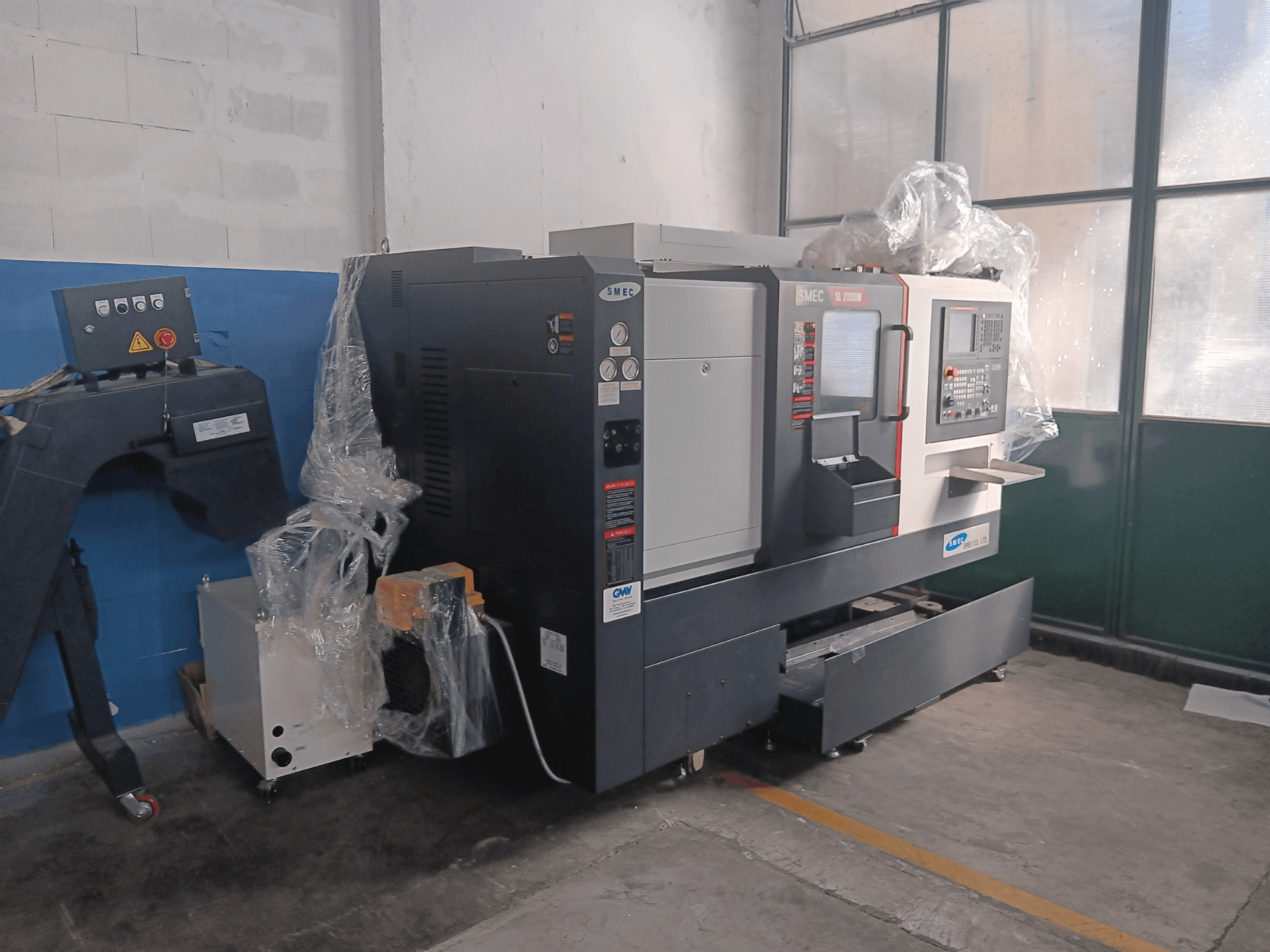 SMEC SL2000M B TYPE horizontale draaimachine, zijaanzicht, met bedieningspaneel en plastic beschermfolie.