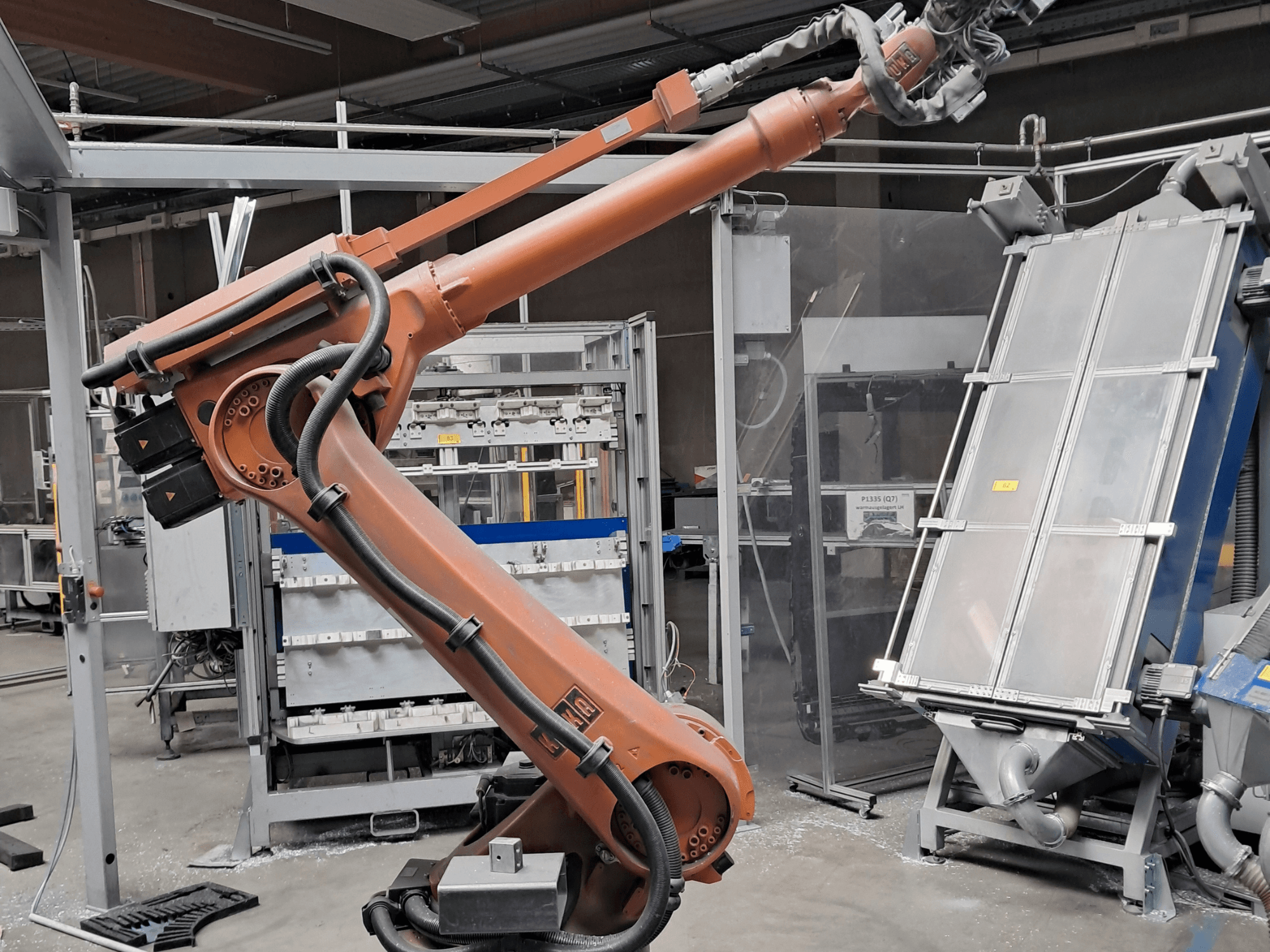 KUKA KR 30L16-2-robotarm in een fabrieksomgeving, zijaanzicht met kabels en mechanische onderdelen.