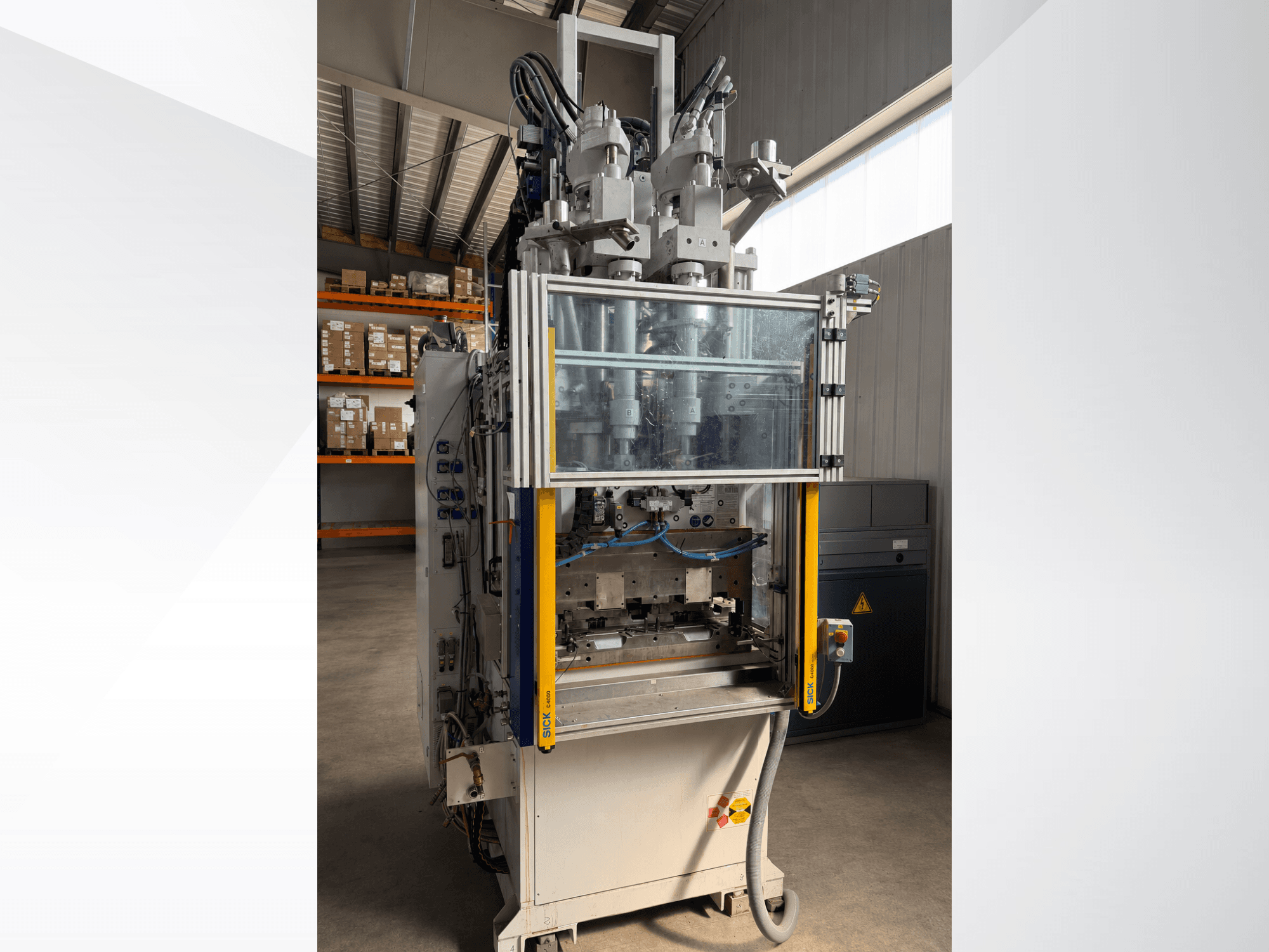 Battenfeld CM 40 verticale spuitgietmachine, vooraanzicht met transparant paneel, waarop het bedieningspaneel en de spuitgietcomponenten te zien zijn.