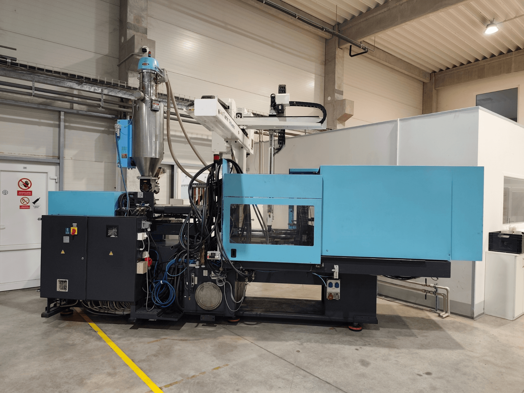 Vooraanzicht van een DEMAG Ergotech Extra 160-430 hydraulische spuitgietmachine, met zichtbaar bedieningspaneel en trechter.