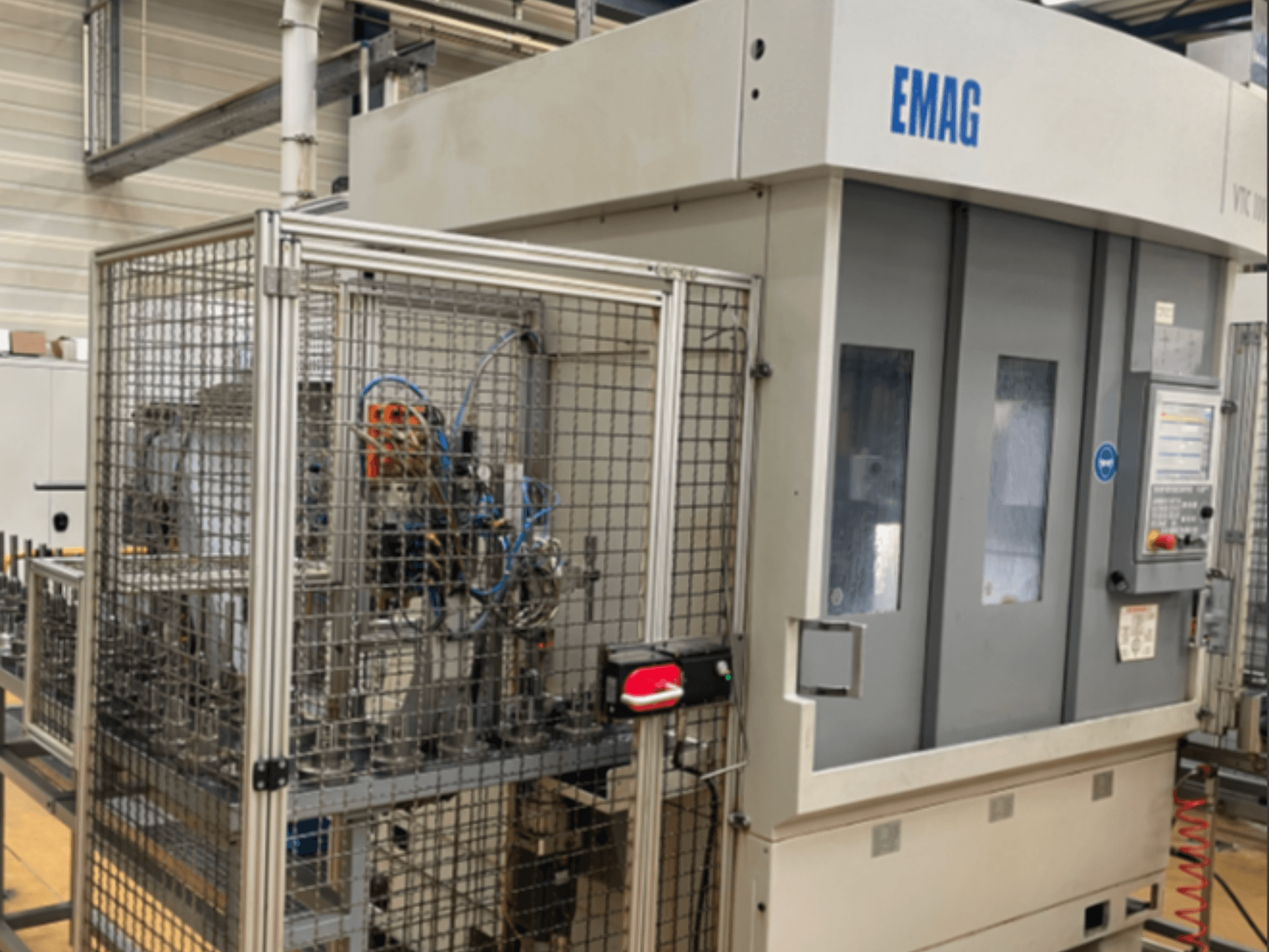 EMAG VTC 100 verticale draaimachine in zijaanzicht, met details van het bedieningspaneel en de veiligheidshekken.
