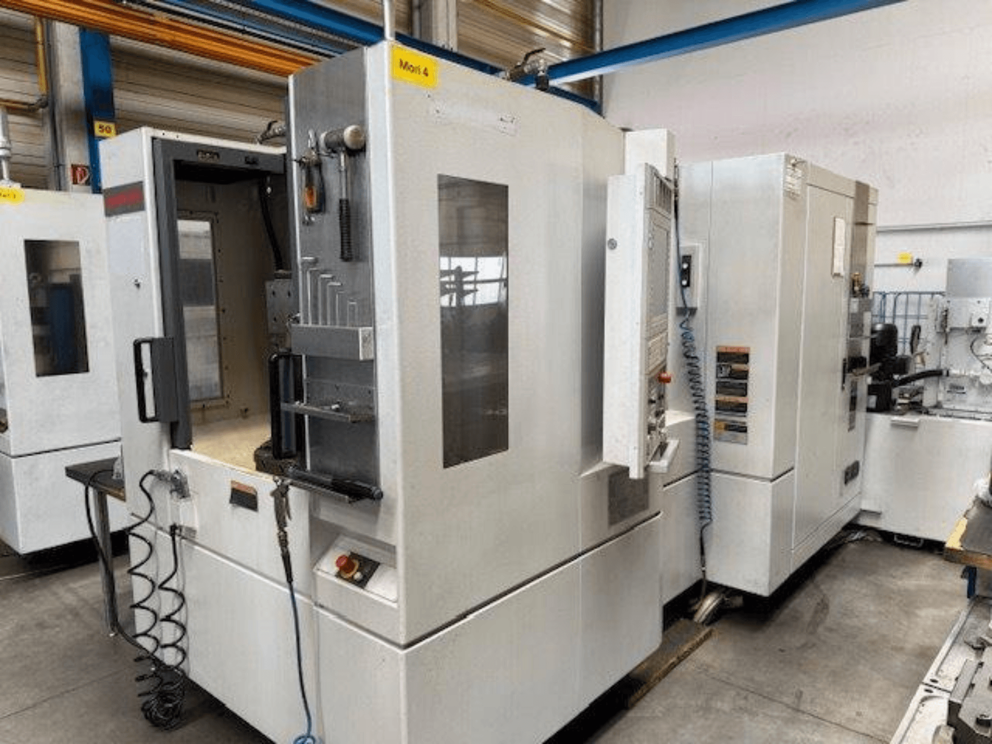 MORI SEIKI NH4000 DCG horizontaal bewerkingscentrum getoond vanaf de voorkant, met een open deur en details van het bedieningspaneel.