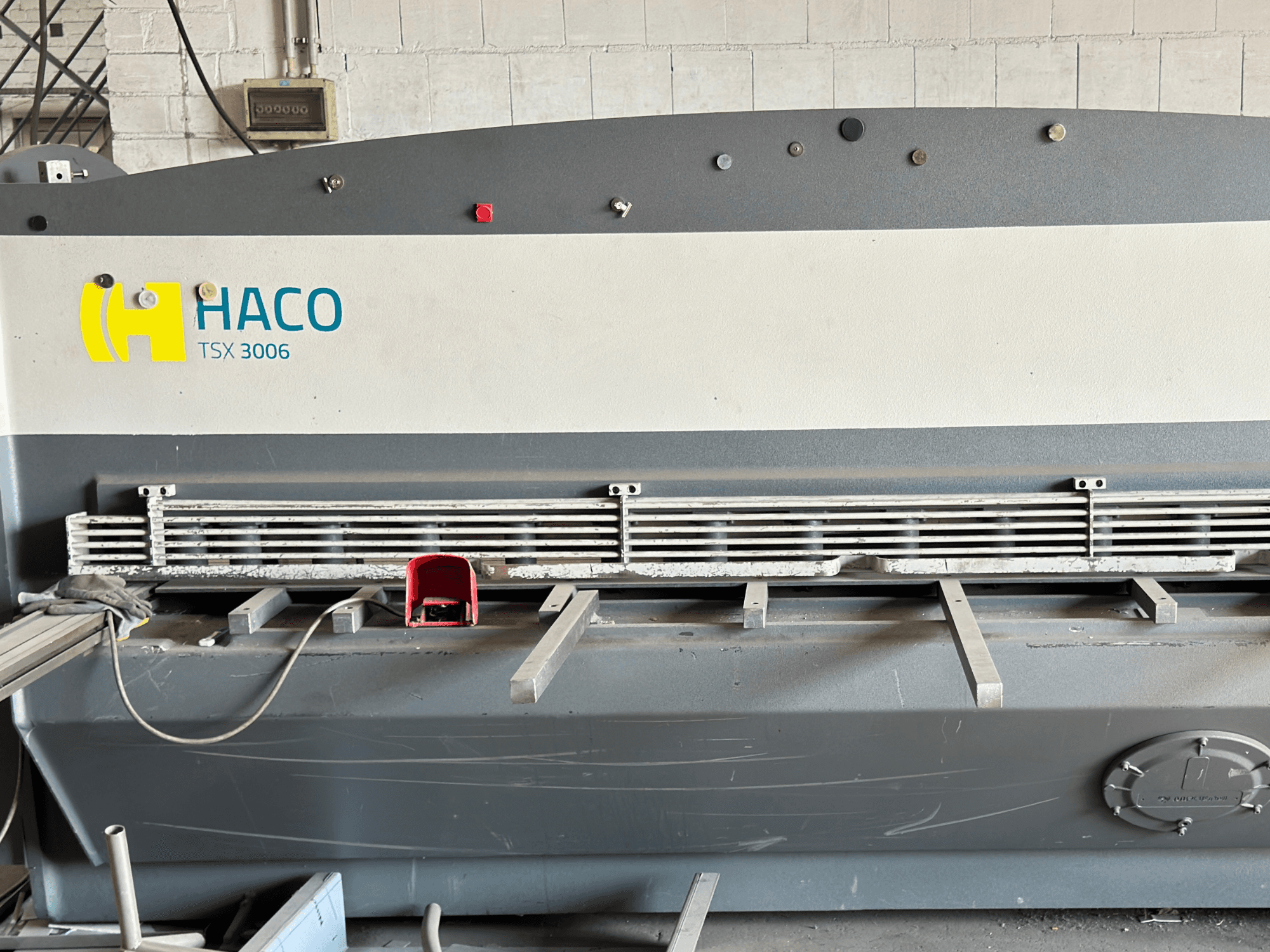 HACO TSX3006 MOT hydraulische schaarmachine, vooraanzicht, met metalen schaarmessen en bedieningspaneel, met werkingsdetails.
