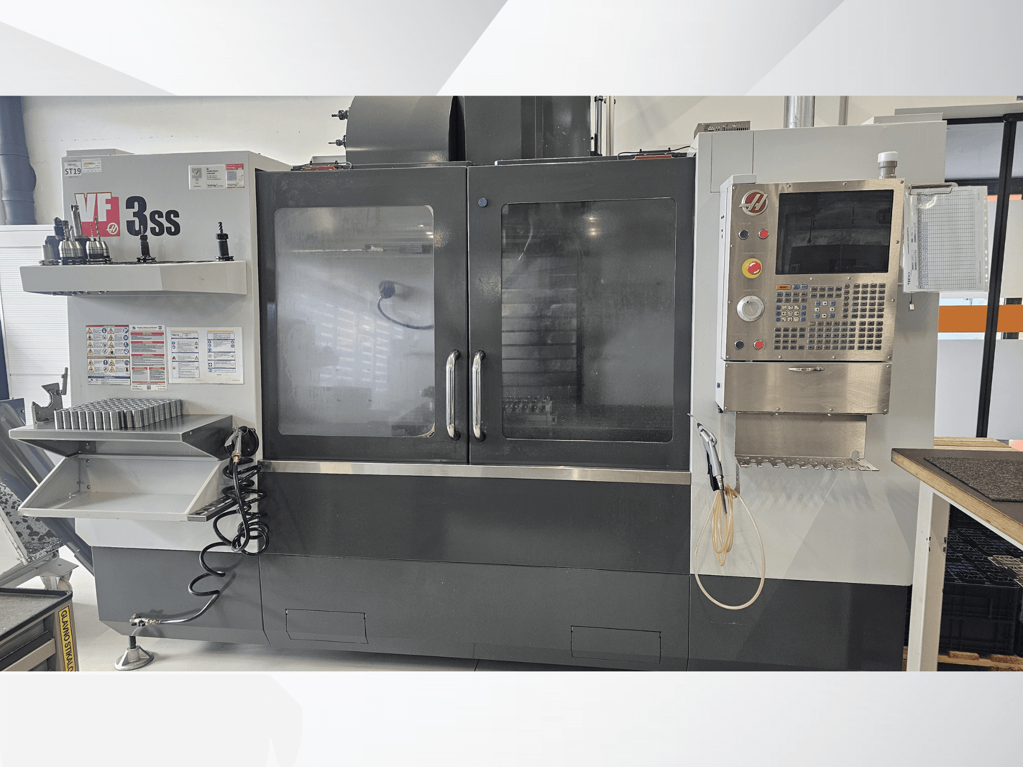 HAAS VF-3SS verticaal bewerkingscentrum, vooraanzicht, met bedieningspaneel, gereedschapsrek en grote glazen deur.