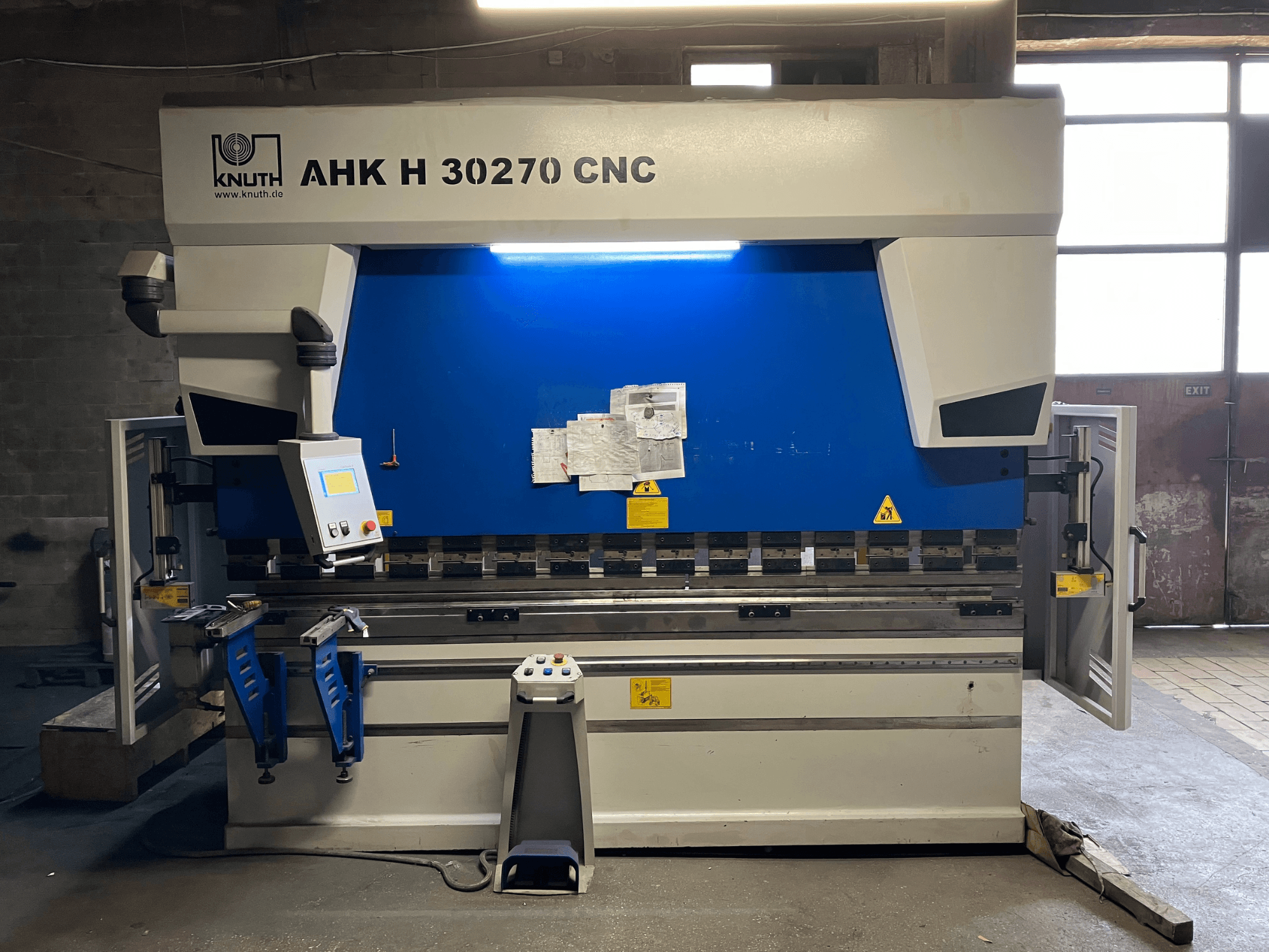 KNUTH AHK H 30270 CNC-kantpers in een werkplaats, vooraanzicht, met het bedieningspaneel en het blauw-witte ontwerp in beeld, met geopende zijdeur.