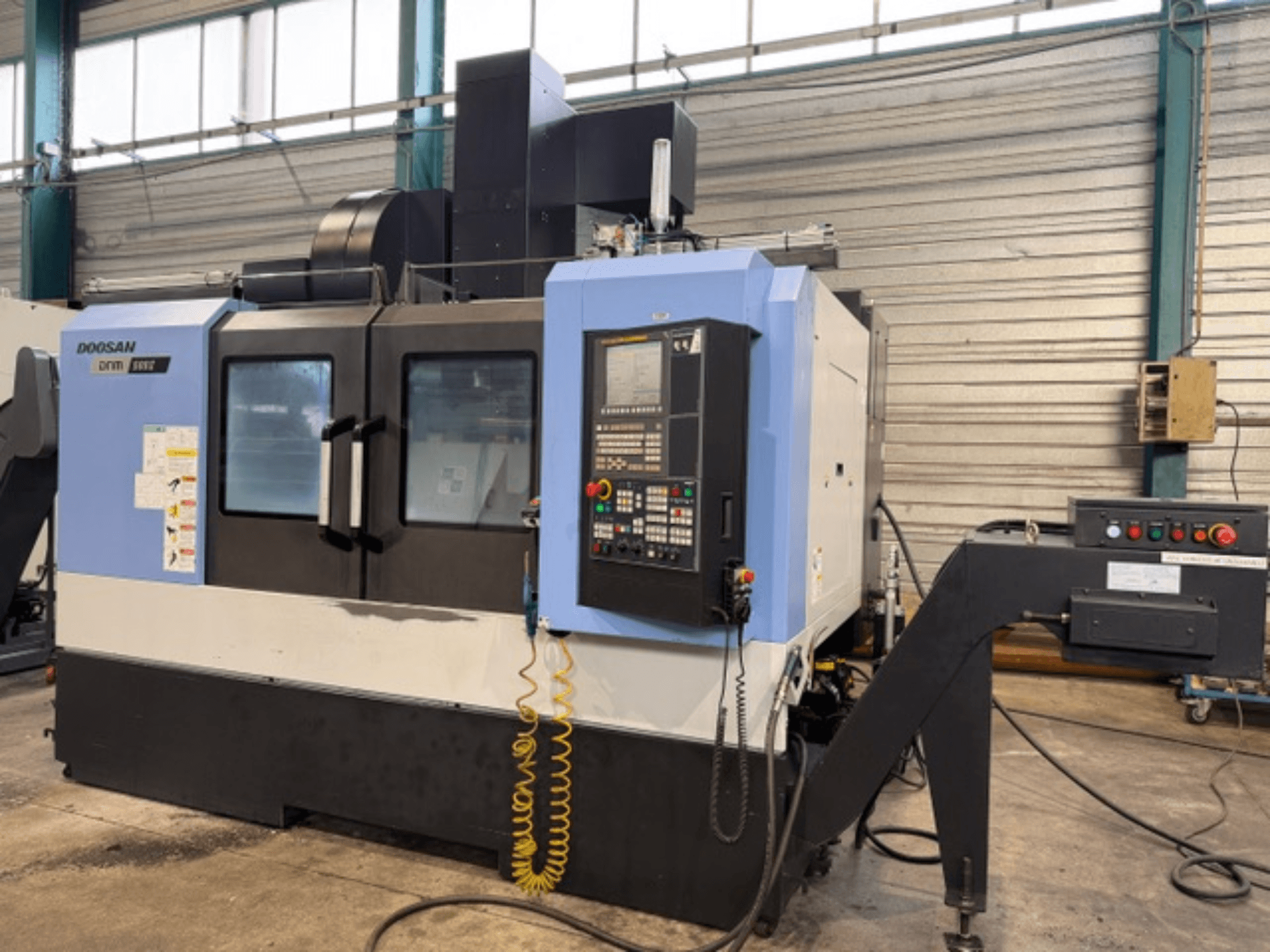 Doosan DNM 500II CNC freesmachine in vooraanzicht, met bedieningspaneel en gereedschaphouder, in een fabrieksopstelling.