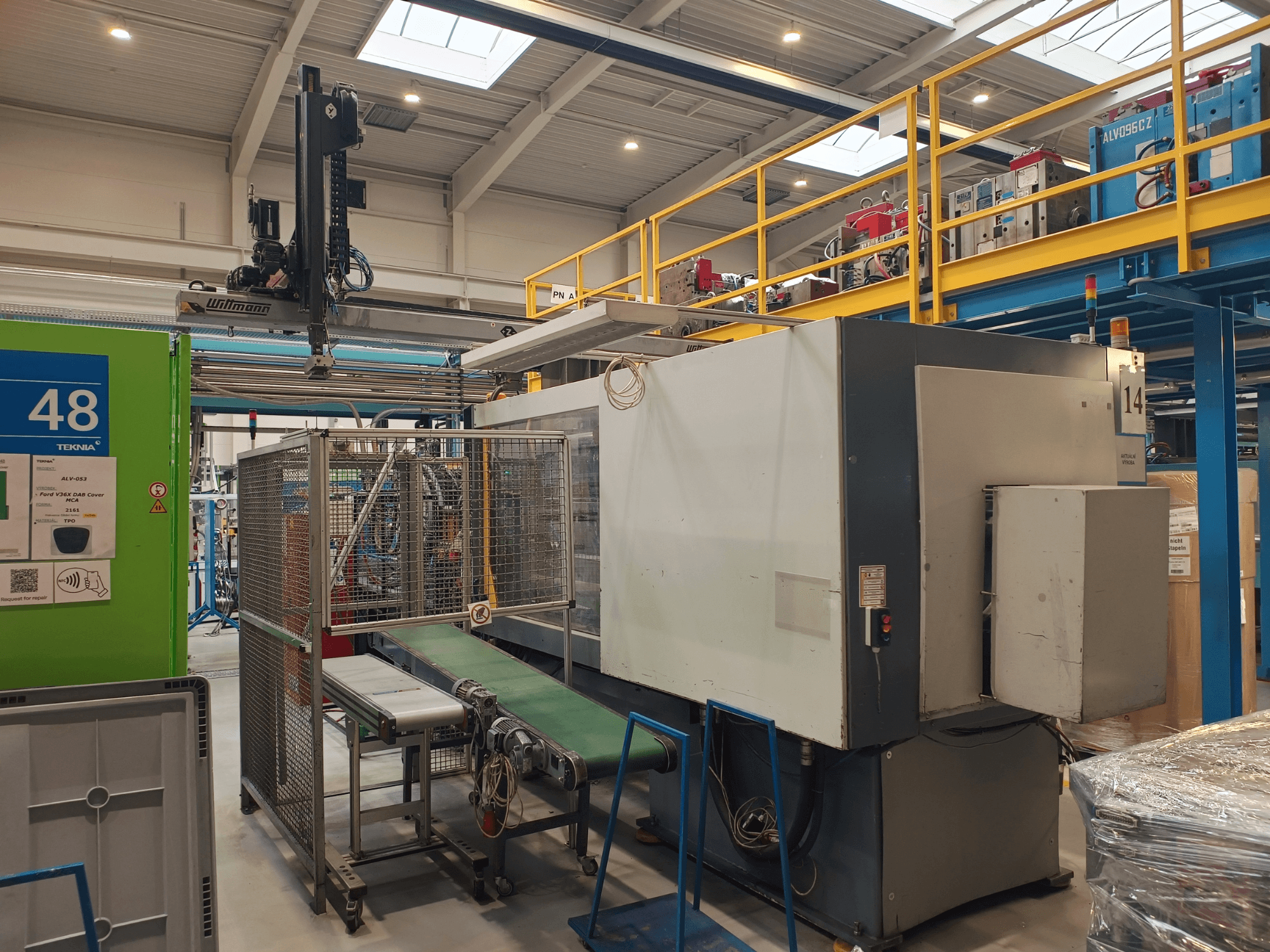 Industriële automatiseringsmachine van Winmon, zijaanzicht met transportband, bedieningspaneel en veiligheidskooi in een fabrieksomgeving.