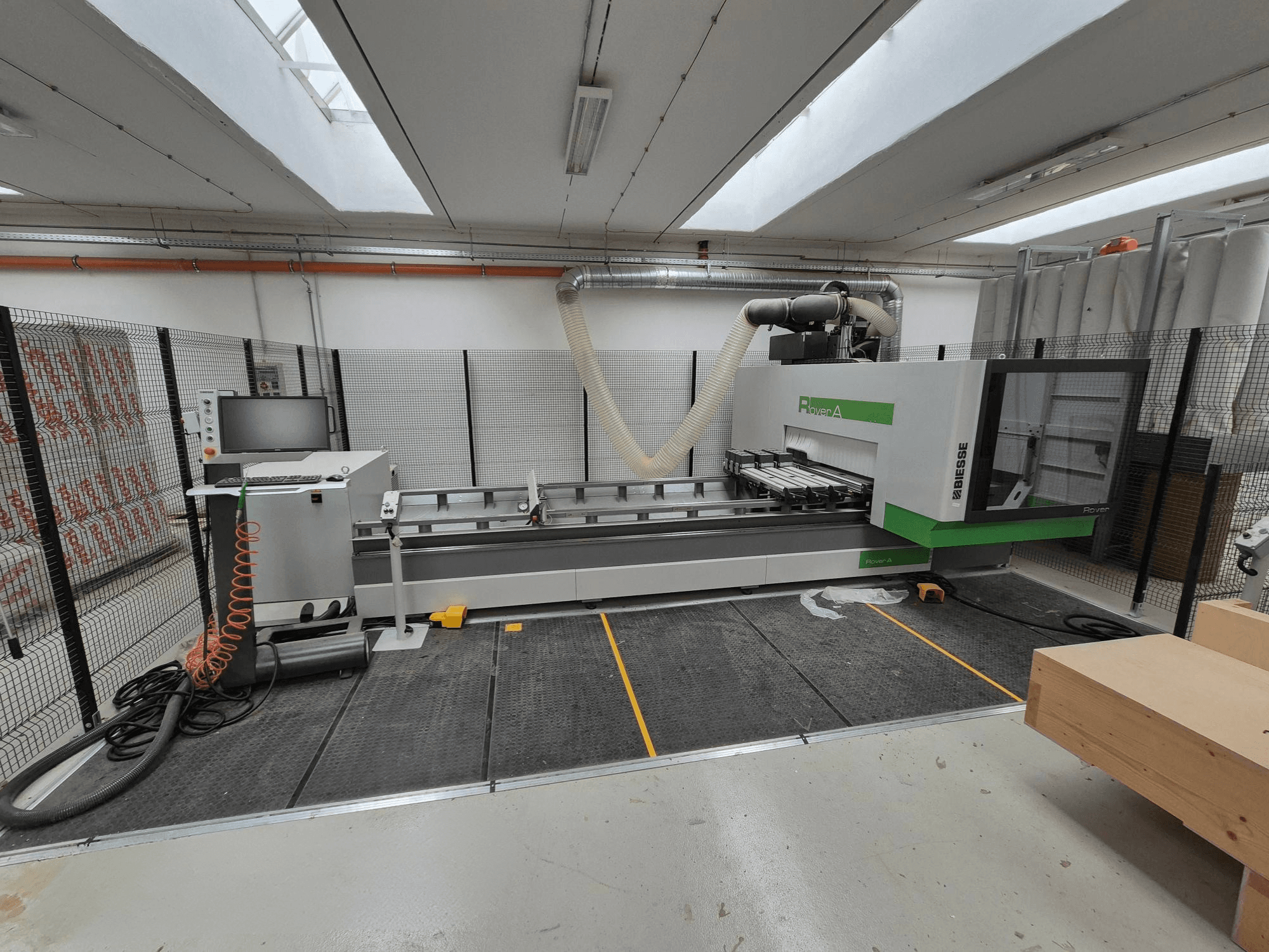 Biesse Rover Een CNC machine in een werkplaats, vooraanzicht. Voorzien van een bedieningspaneel, vacuümsysteem en werkoppervlak.