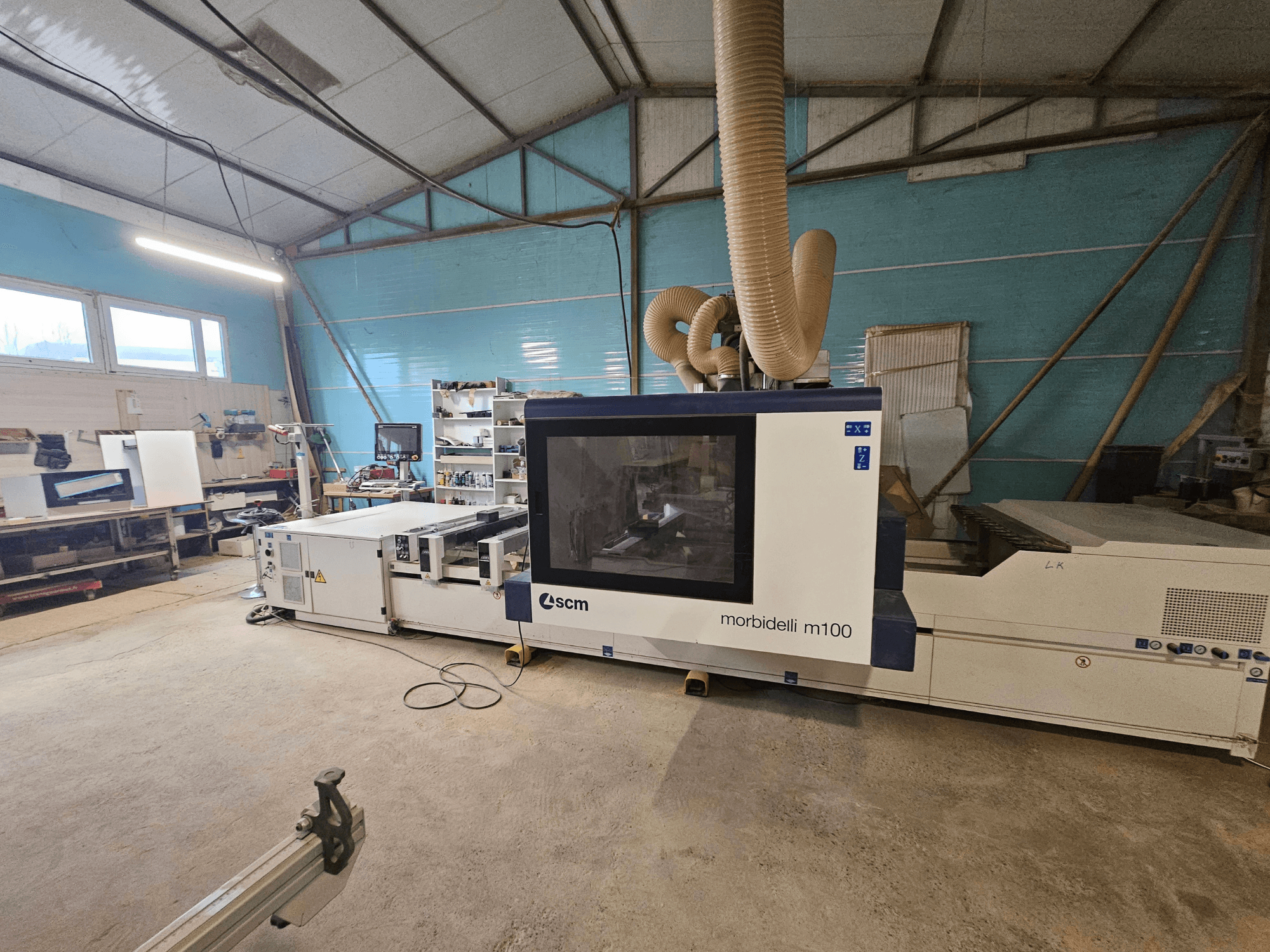 SCM Morbidelli M100 CNC machine in een werkplaats, vooraanzicht, met stofafzuigsysteem en bedieningspaneel.